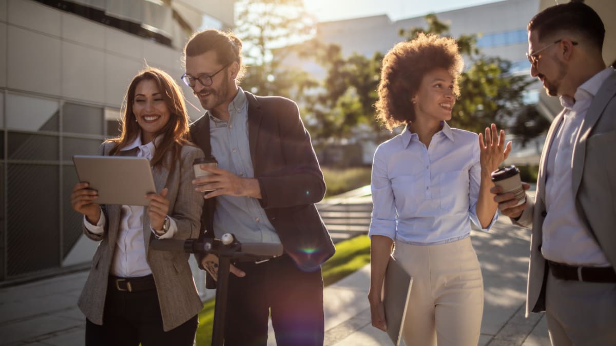 a group of young business professionals walking and talking together outside