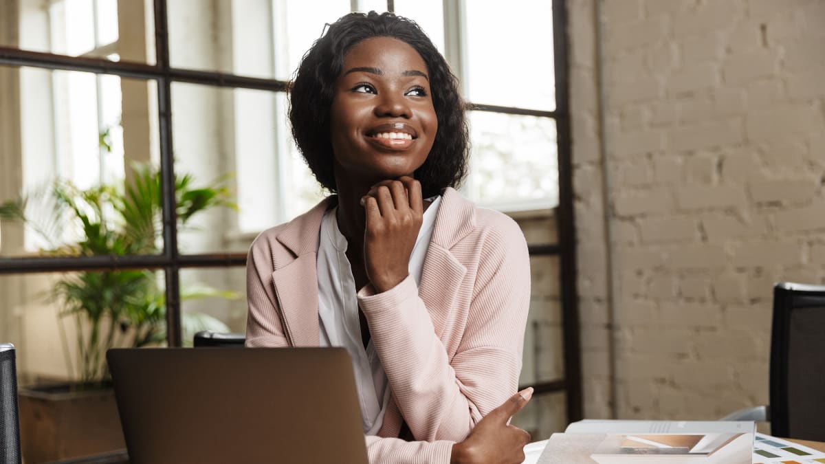 college student sitting in front of a laptop smiling