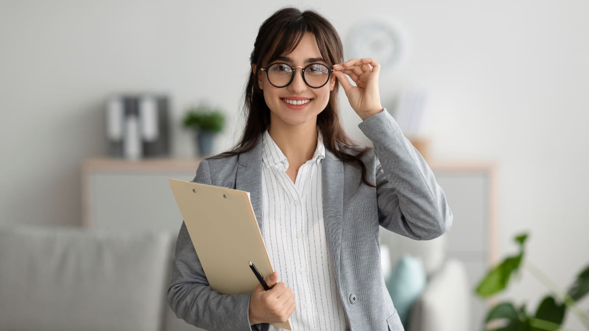 college student standing in an office while holding a clipboard