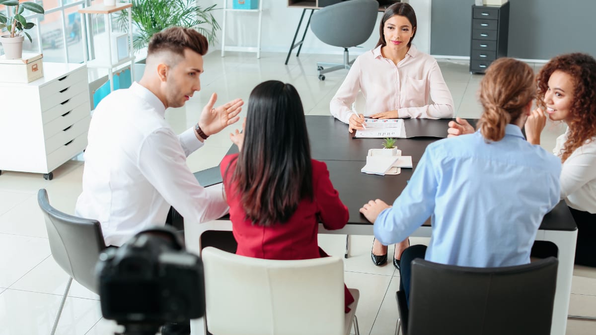 a team of human resource managers sitting around a table talking together