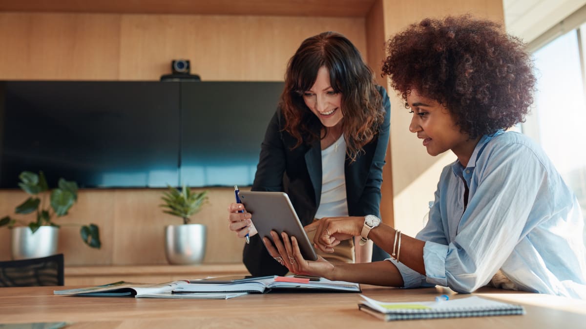 two business professionals looking at a tablet together