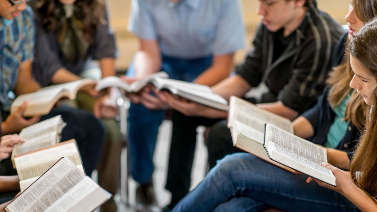 group of college students reading the Bible together