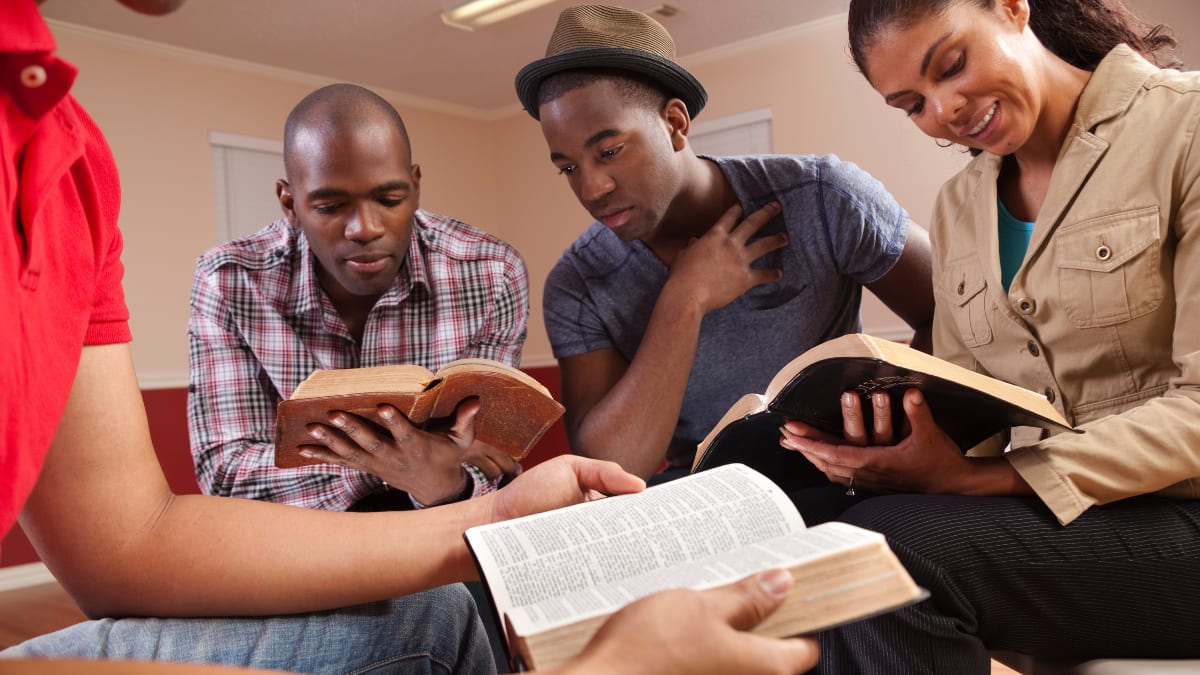 four college students studying the Bible together