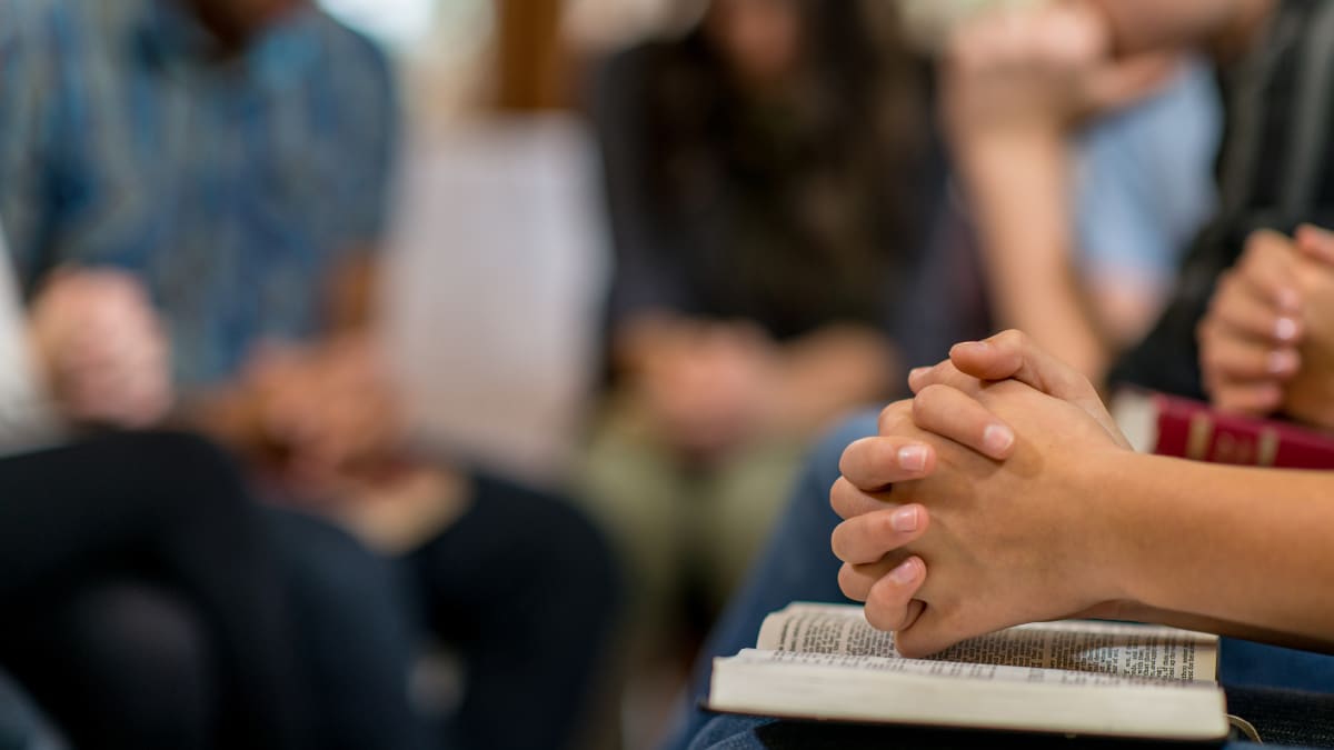 Bible study with a close-up of a student's hands on a Bible