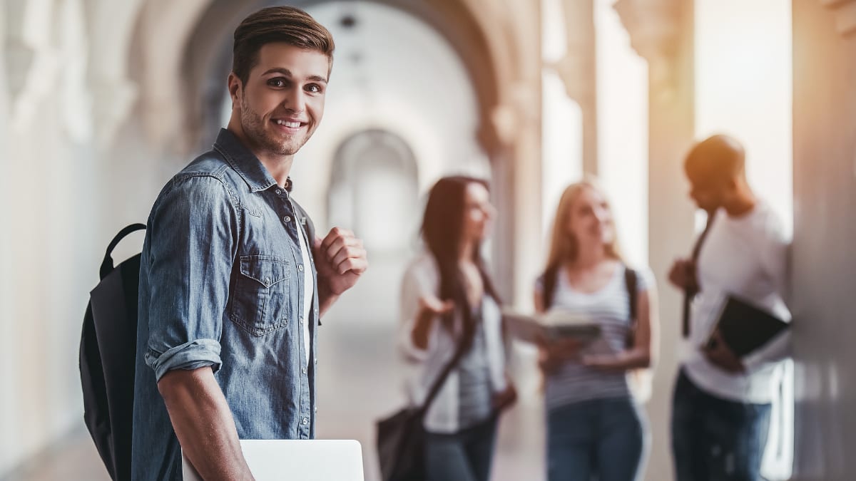 college student standing in a building with other students in the background