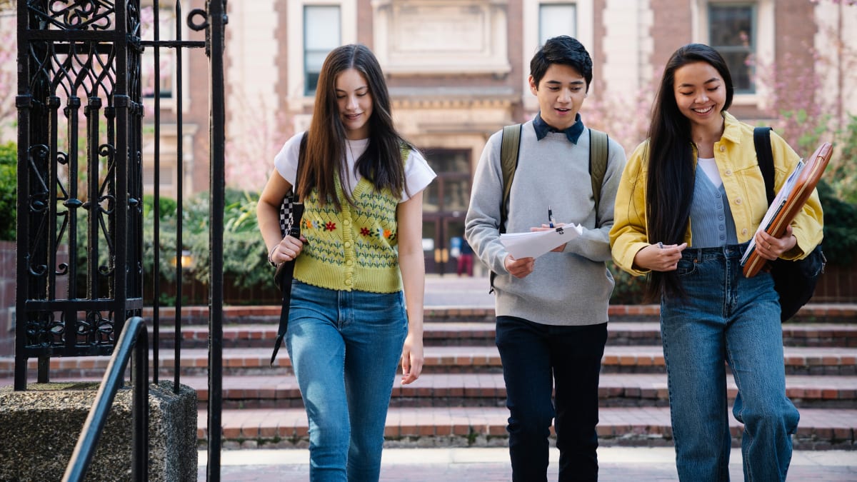 three college students walking on campus together