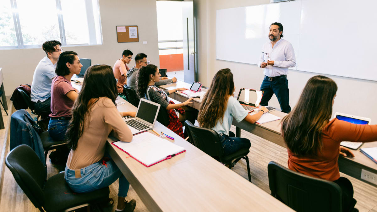 college students in a lecture with a professor at the front of the class