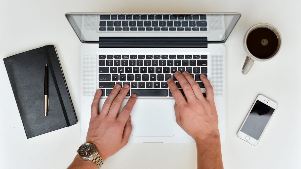 Author's hand typing on laptop