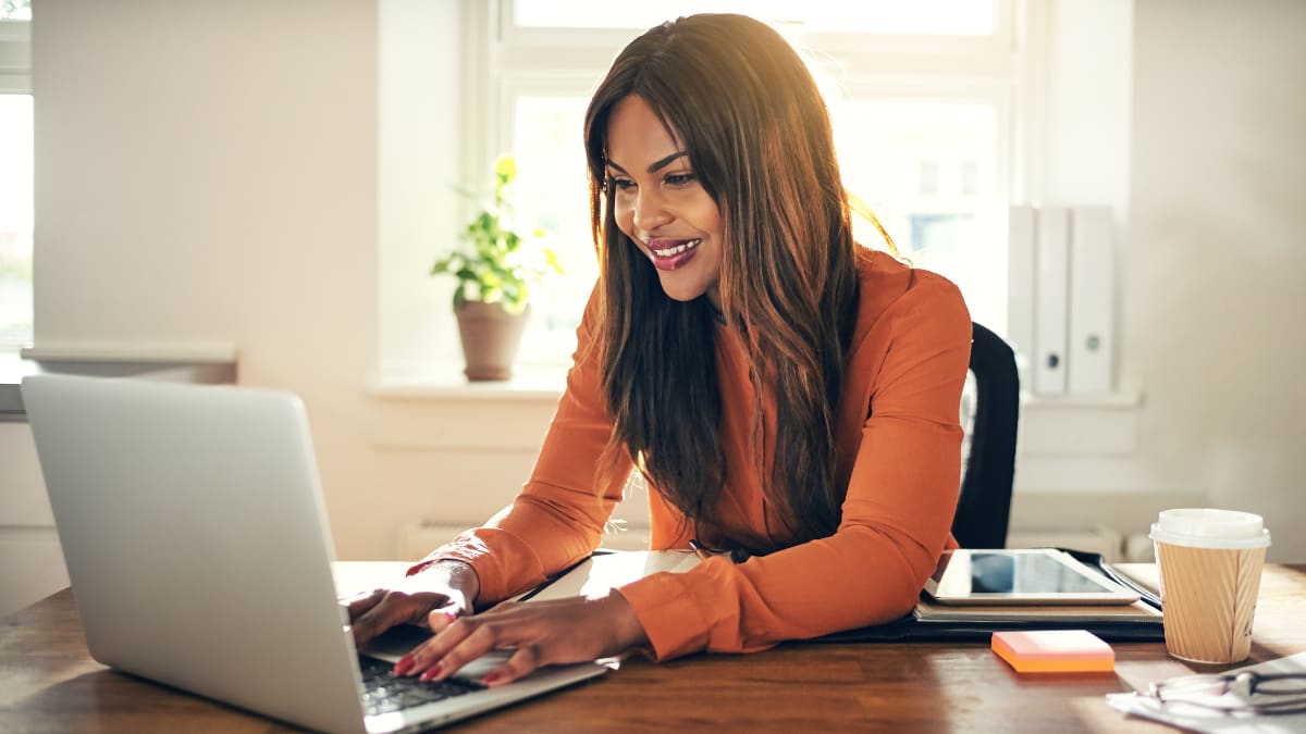 author sitting at a desk typing on a laptop