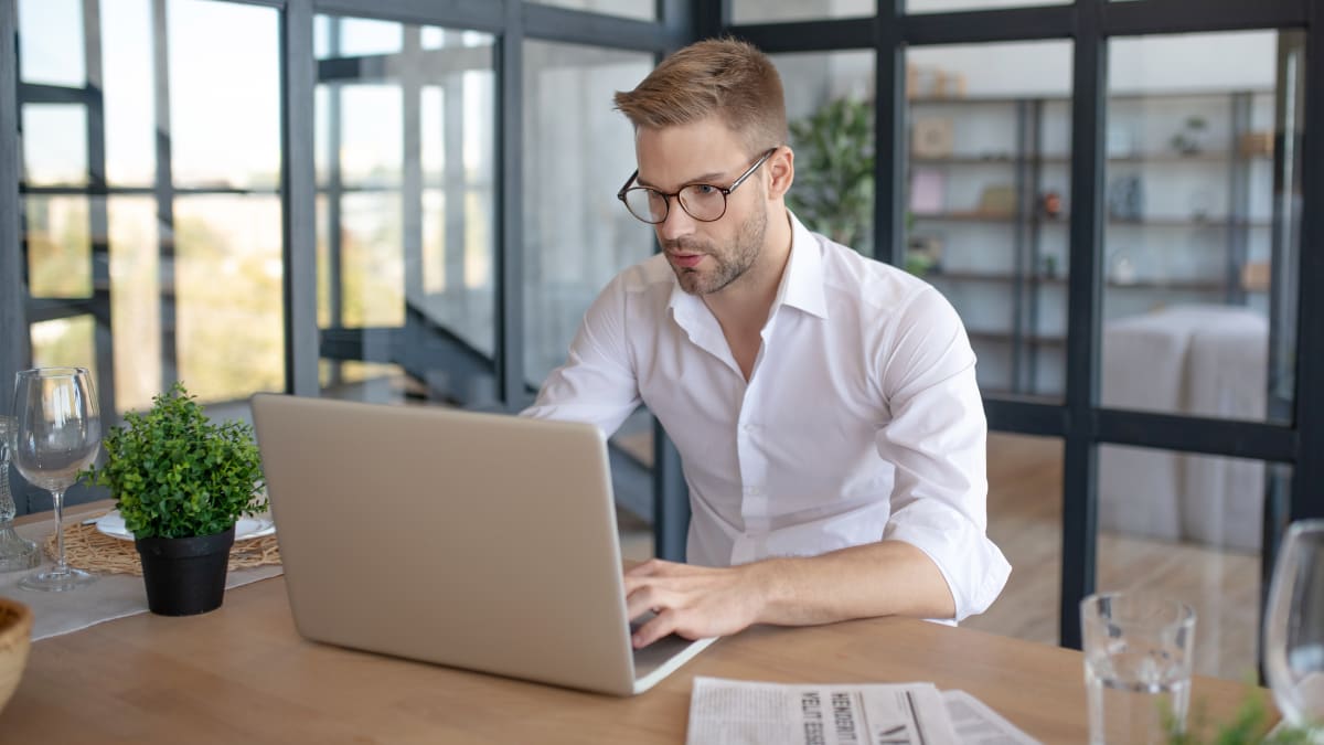 author sitting at a desk typing on a laptop