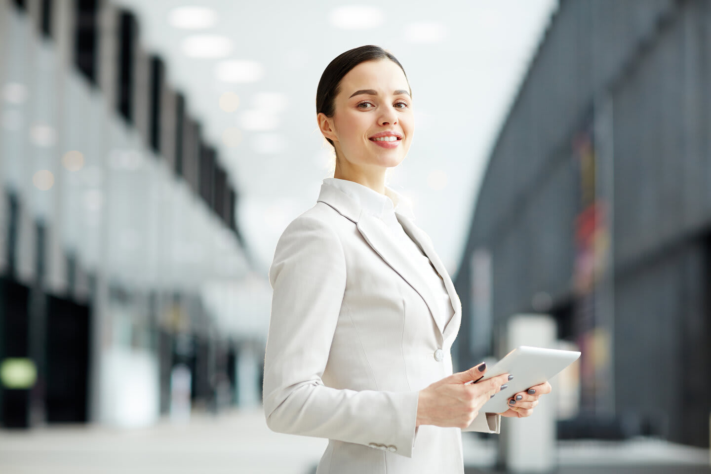 Woman in a suit holding an electronic tablet