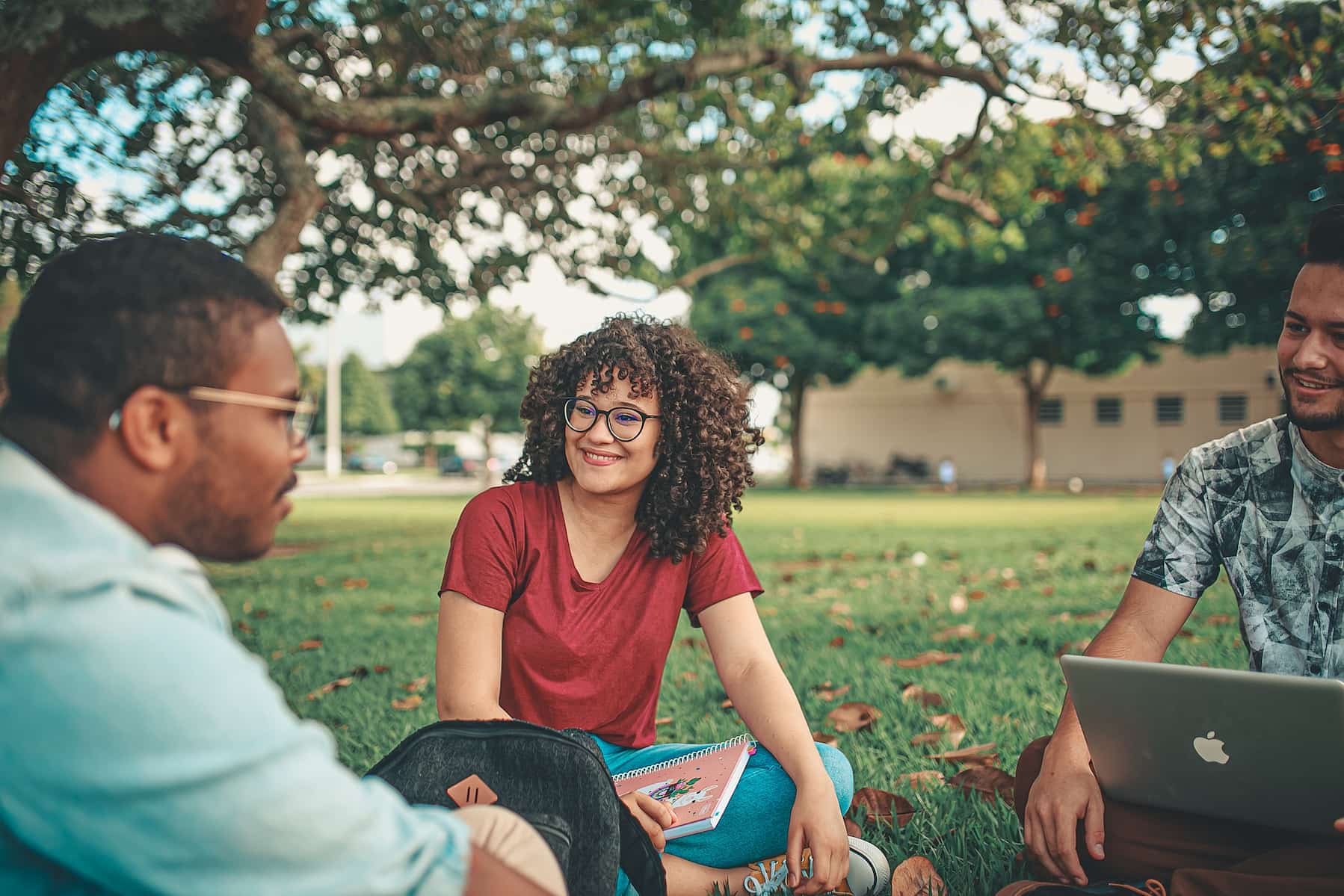 Students sitting on the grass while doing their homework