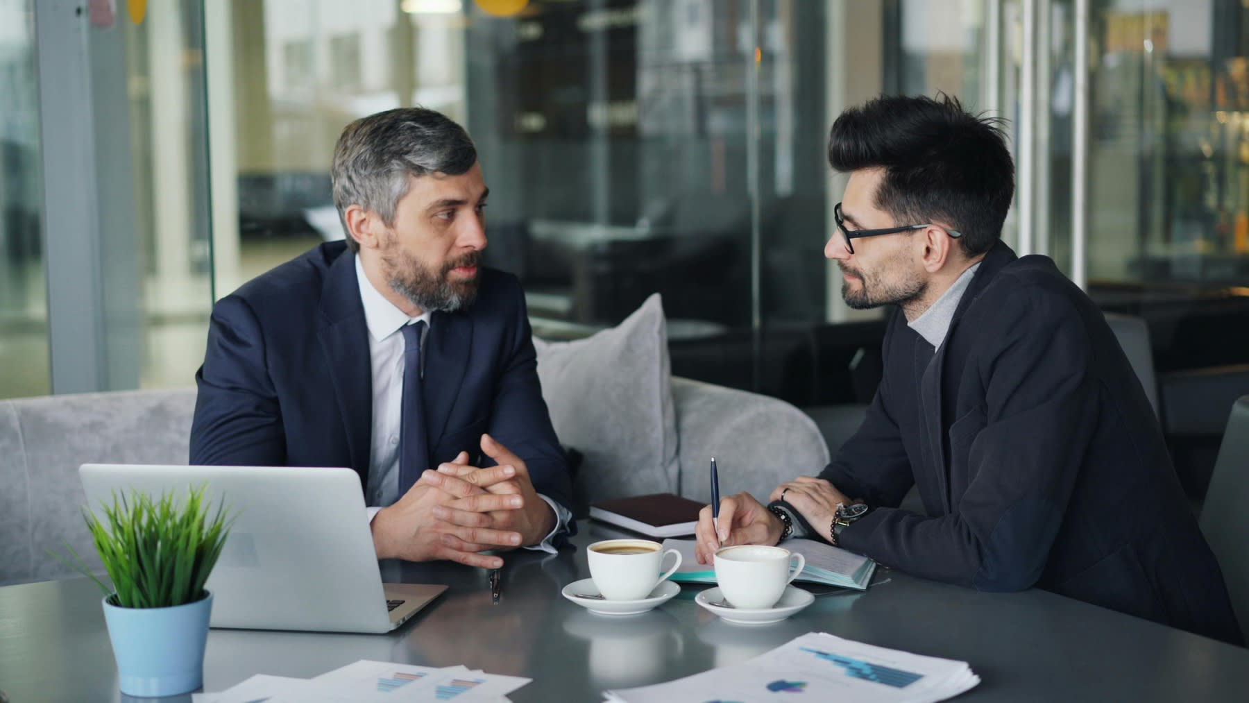 Two men having a serious talk over coffee during a business meeting