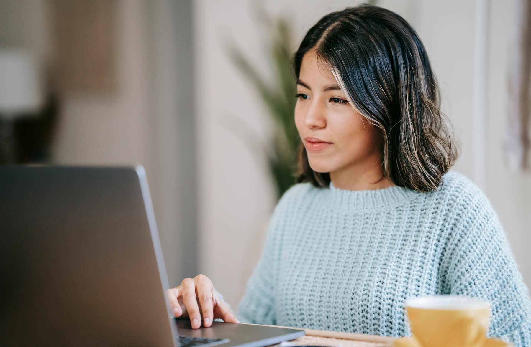 Woman scrolling through her laptop