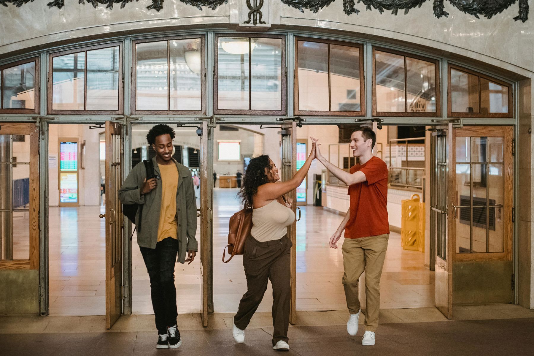 Students high-fiving each other as they exit the school's front doors