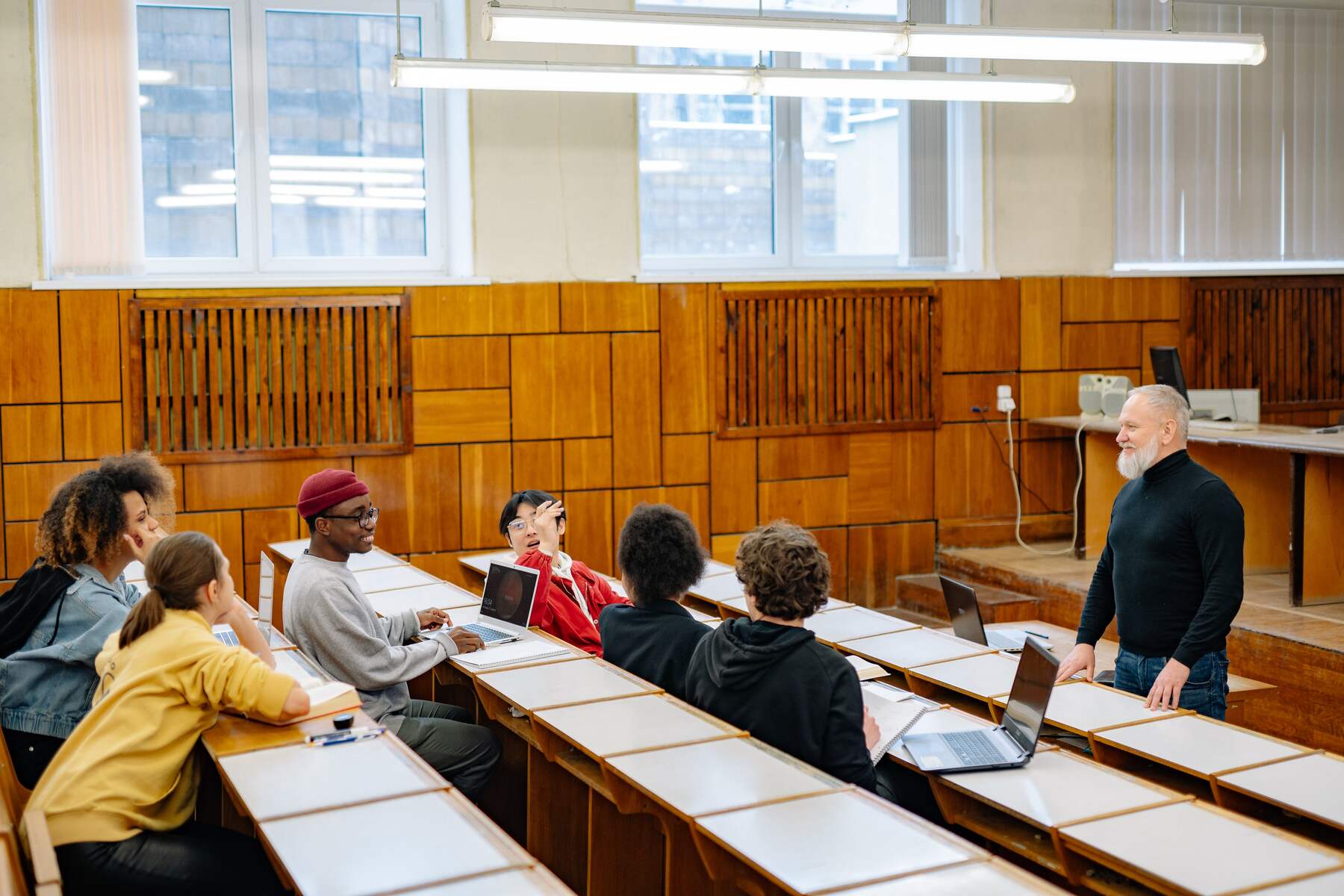 Students sitting in a classroom with a professor standing at the front of the room