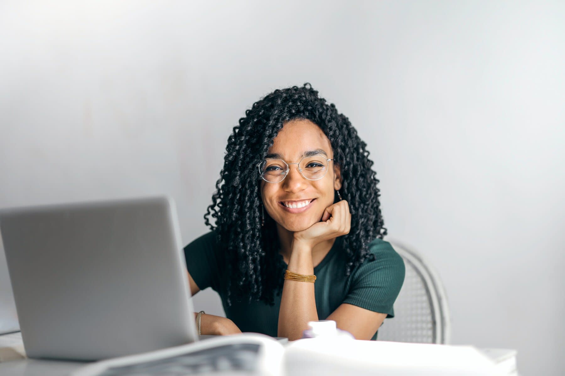 Woman smiling with a laptop in front of her