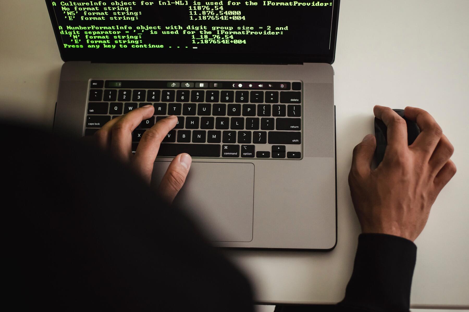 Man using a laptop to code a program