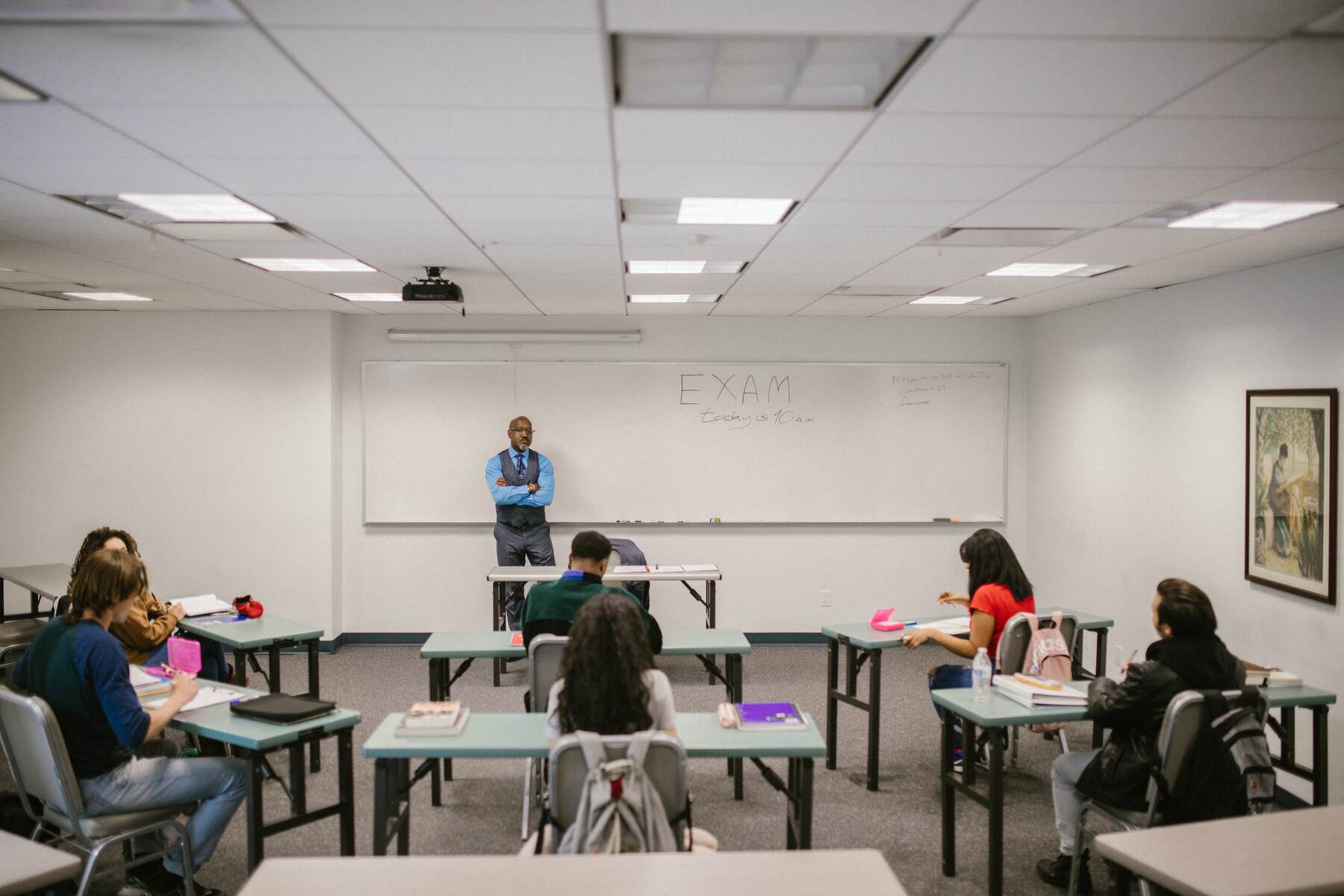 Students in a classroom listening to a teacher