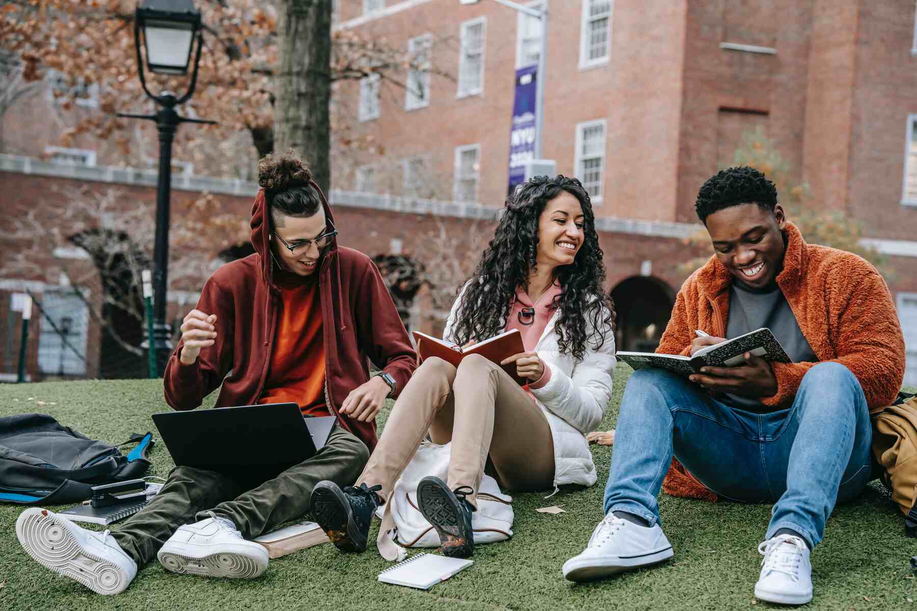Students sitting on the grass inside their campus grounds