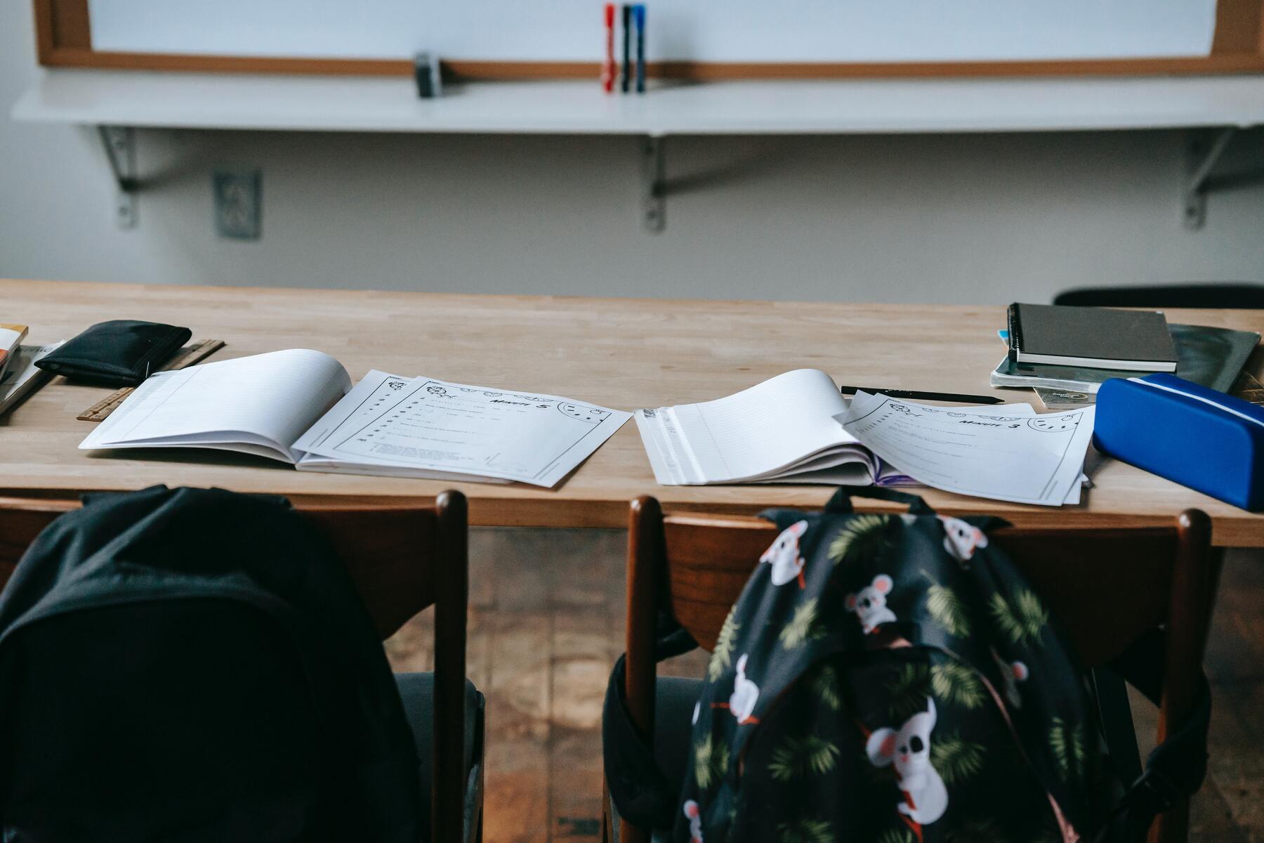 Two notebooks opened on a classroom desk