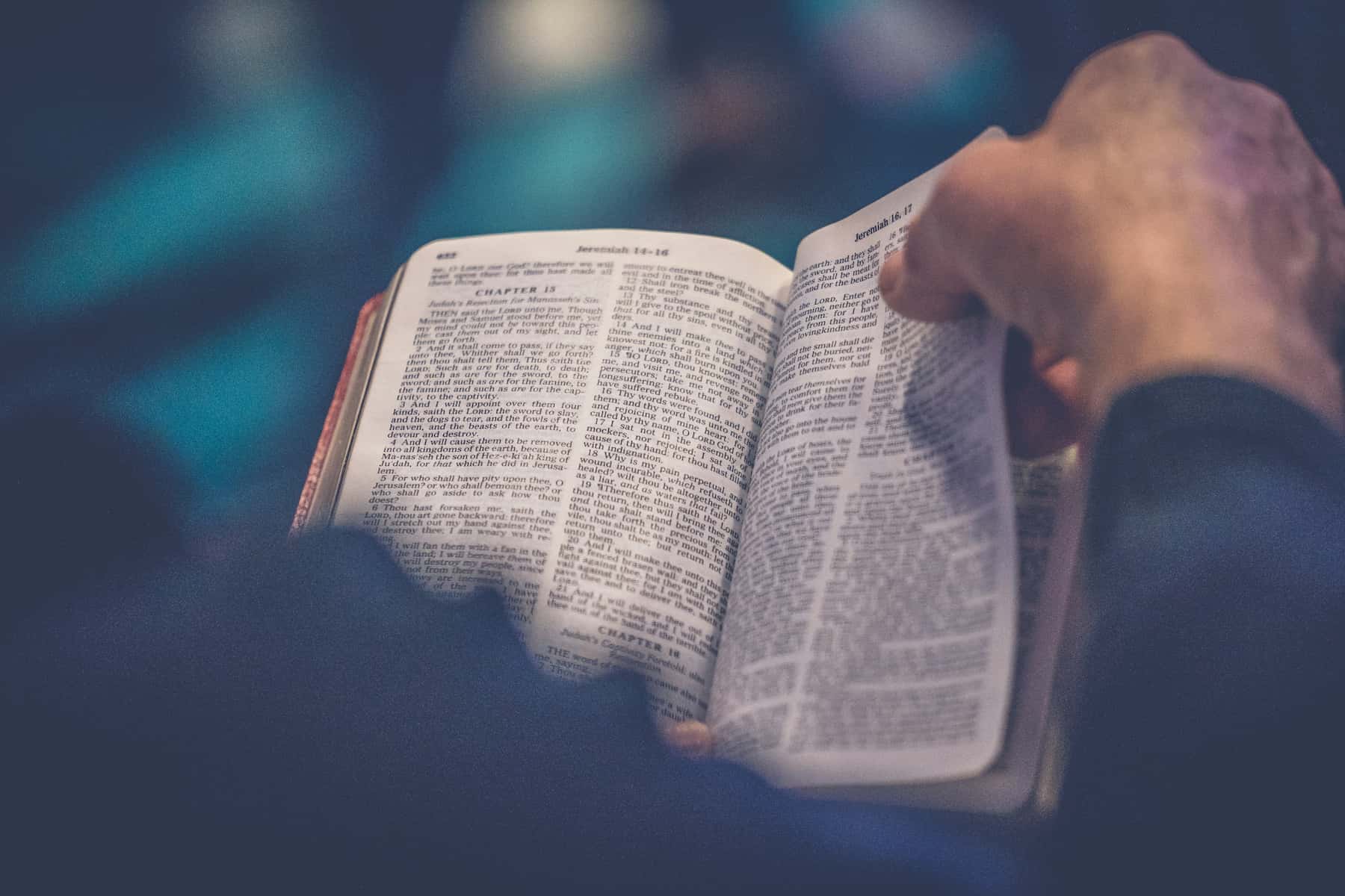 Man turning the pages of a bible