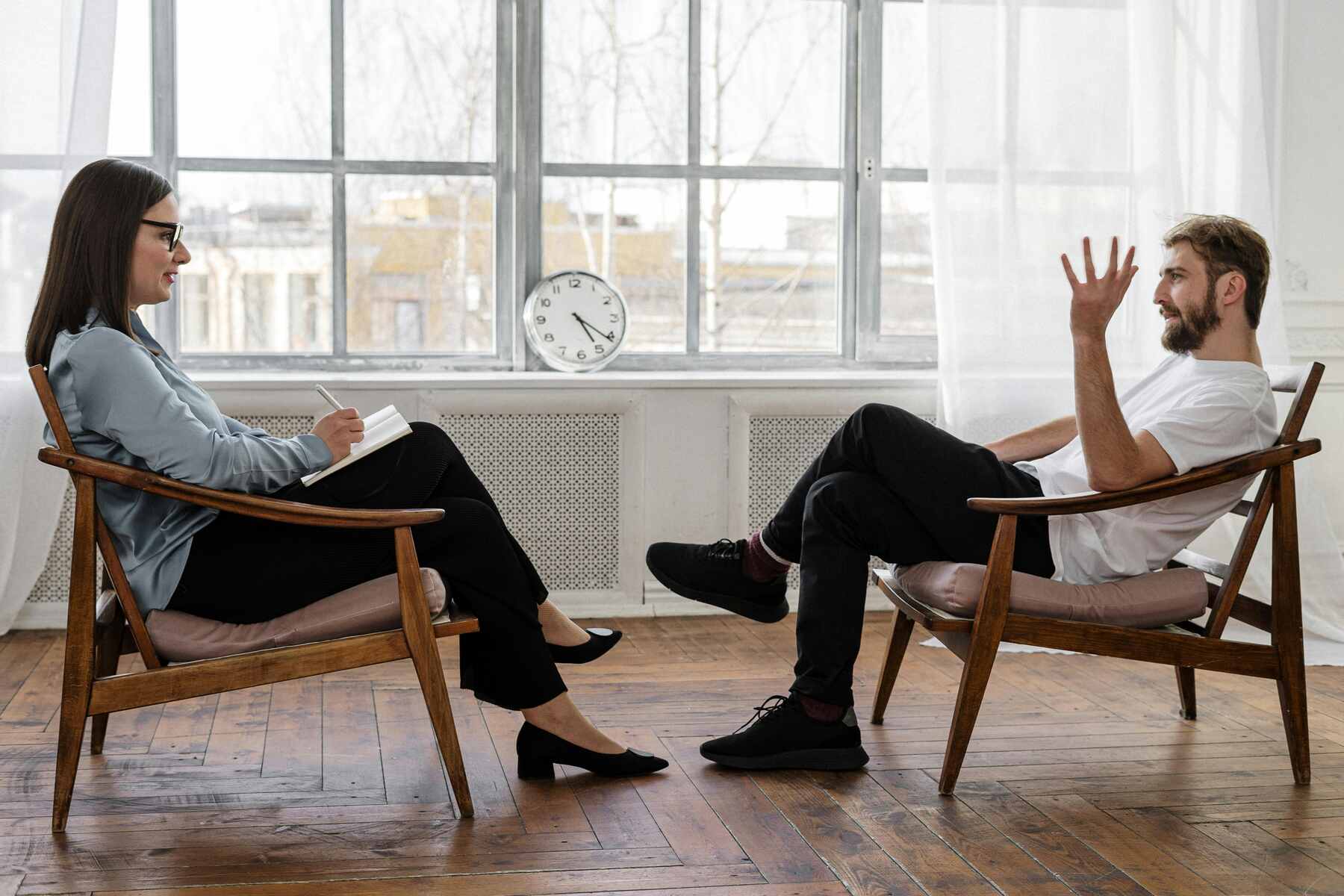 Psychologist sitting across her patient while she listens to his frustrations