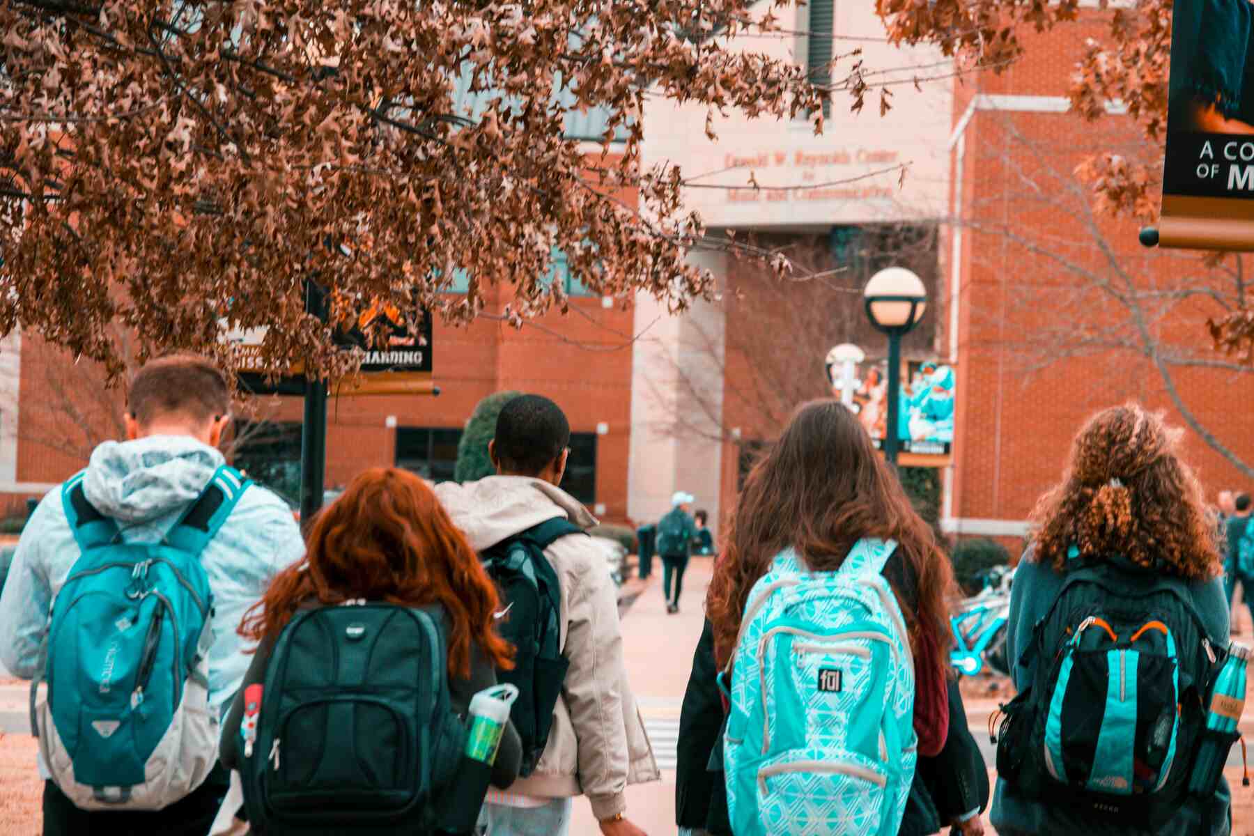 Students wearing backpacks walking around on a campus