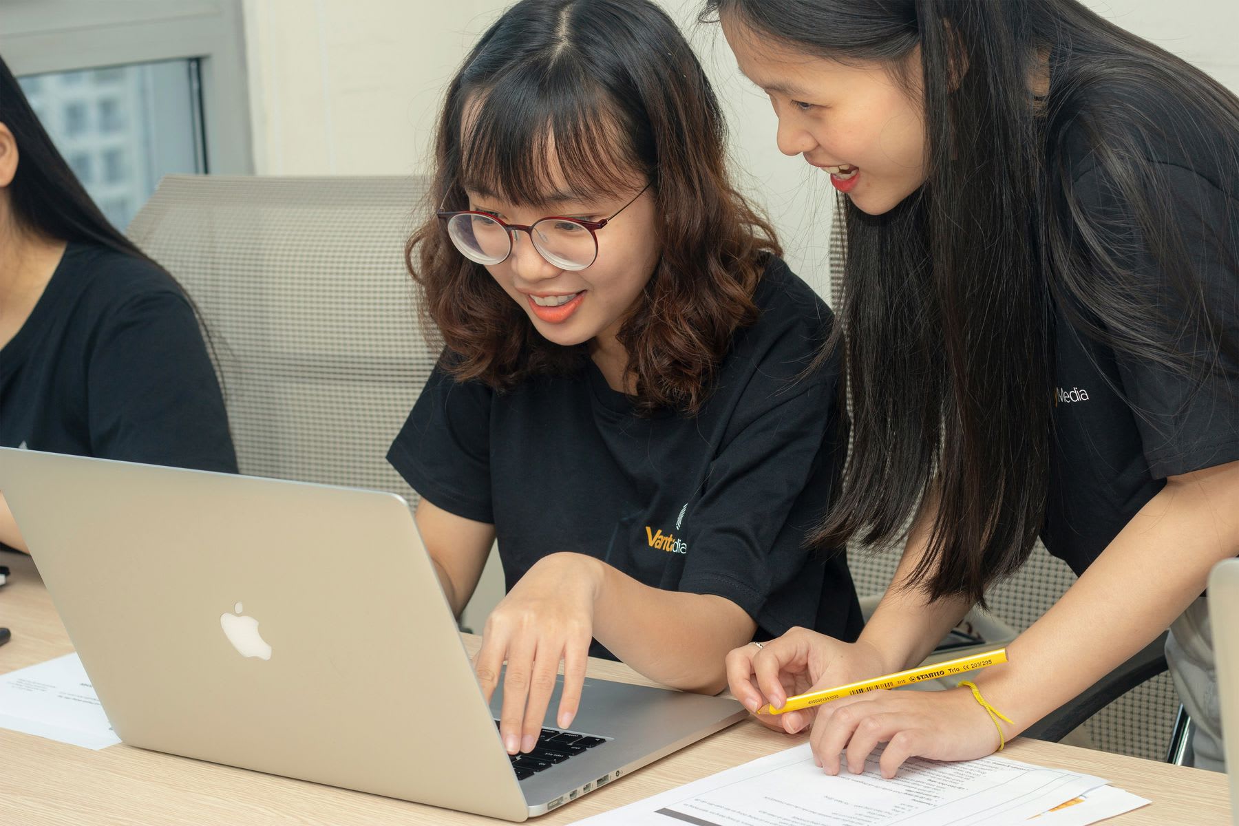 Two women sharing a laptop during a school activity