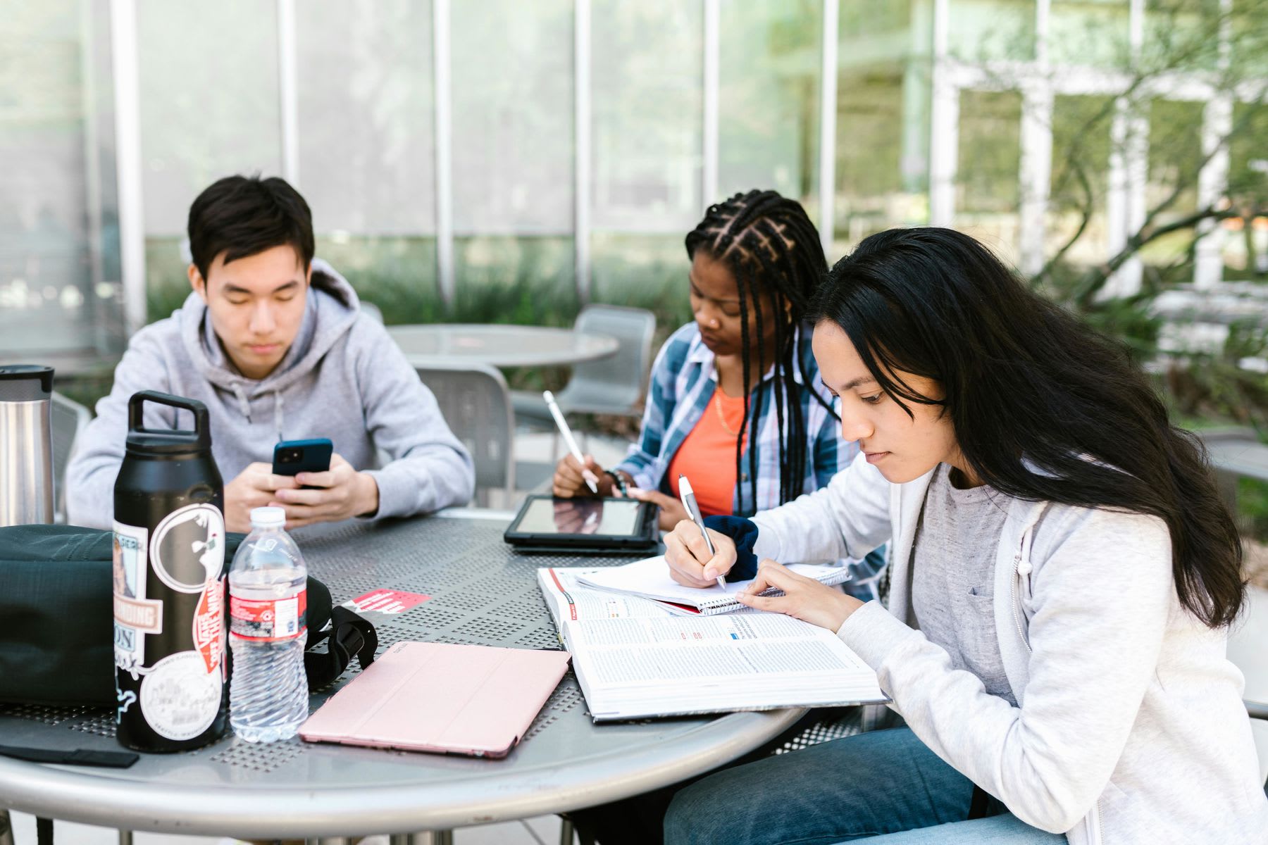 Students sitting on a table outdoors while studying