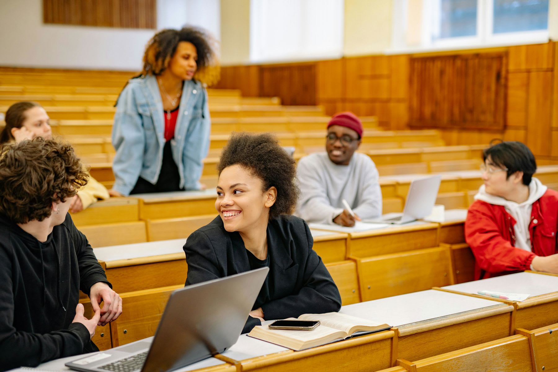 Students talking to each other inside a classroom while waiting for their class to start