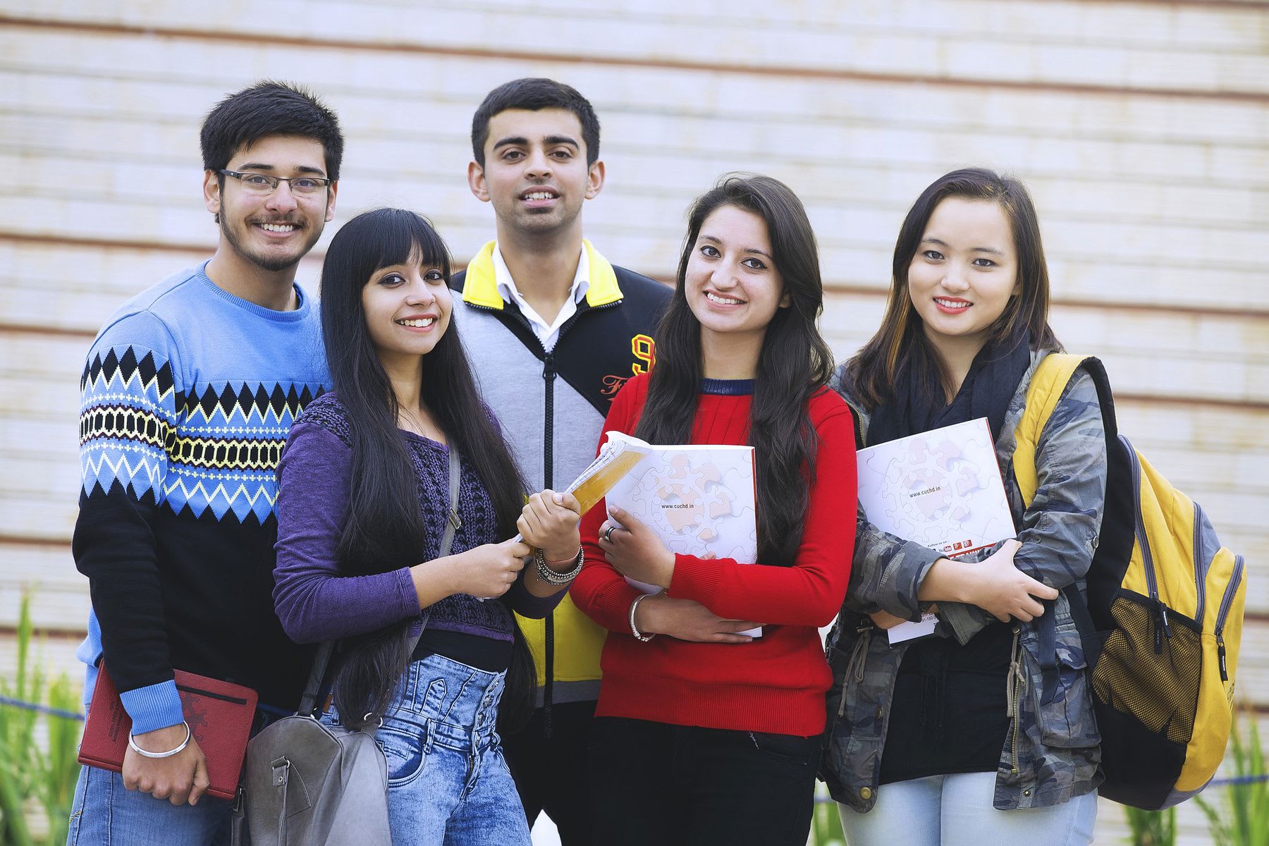 Group of students holding papers and posing for the camera