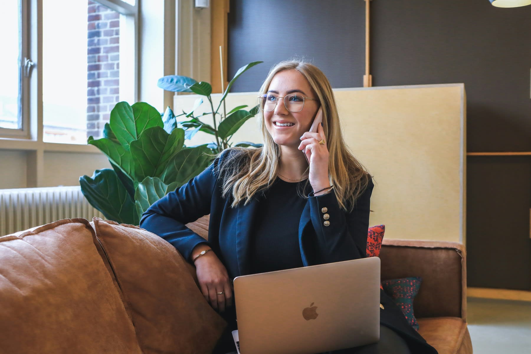 Woman talking on the phone with her laptop on her lap