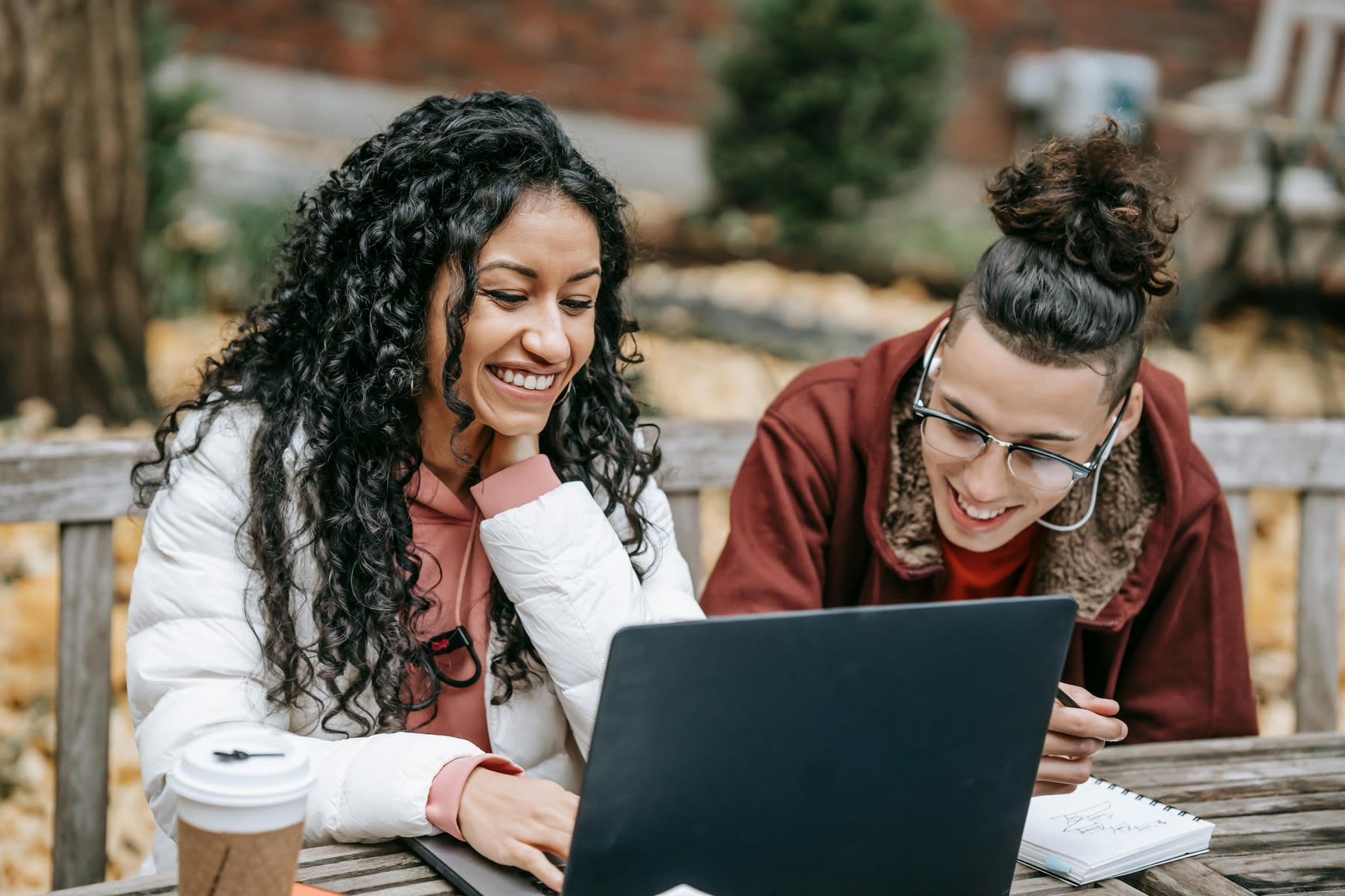 Two women laughing while looking at a laptop screen