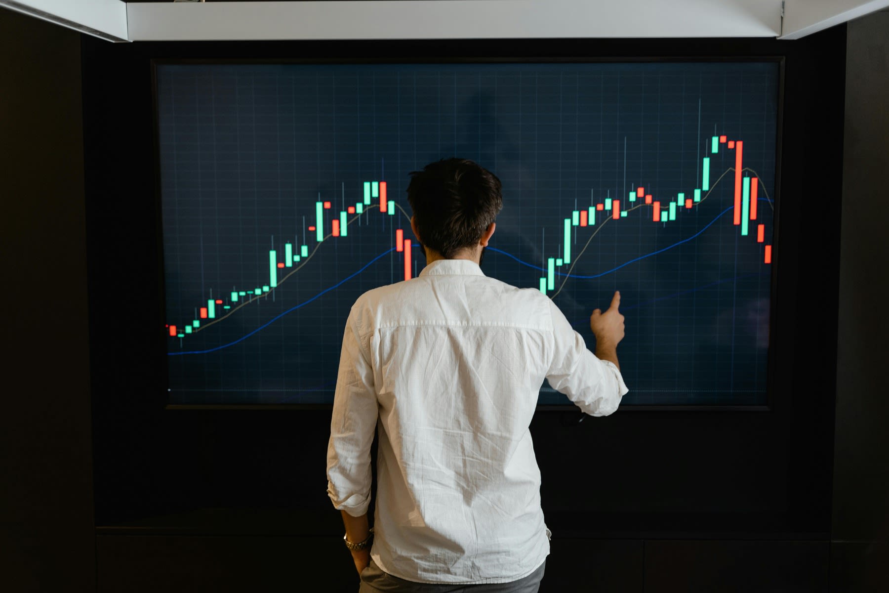 Man looking at a data graph on a large monitor