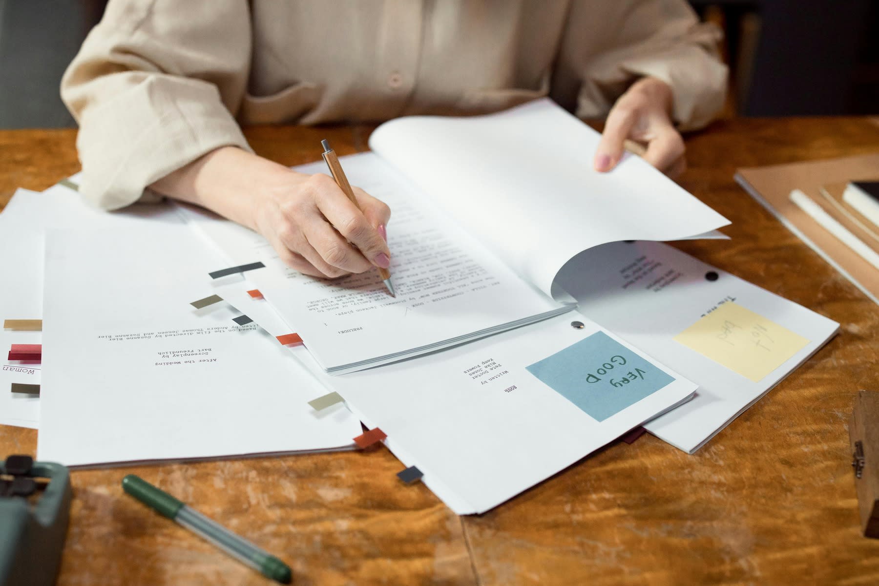 Person writing on a stack of printed reports