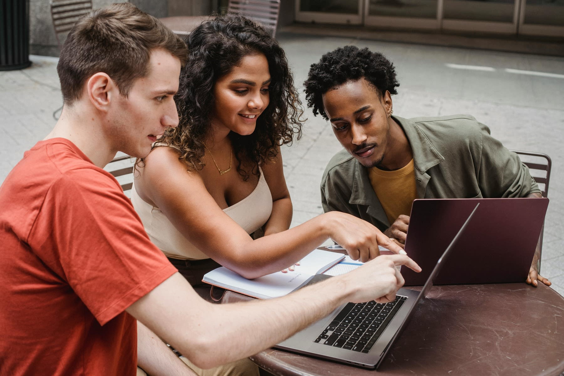 Three students all looking at the same laptop monitor