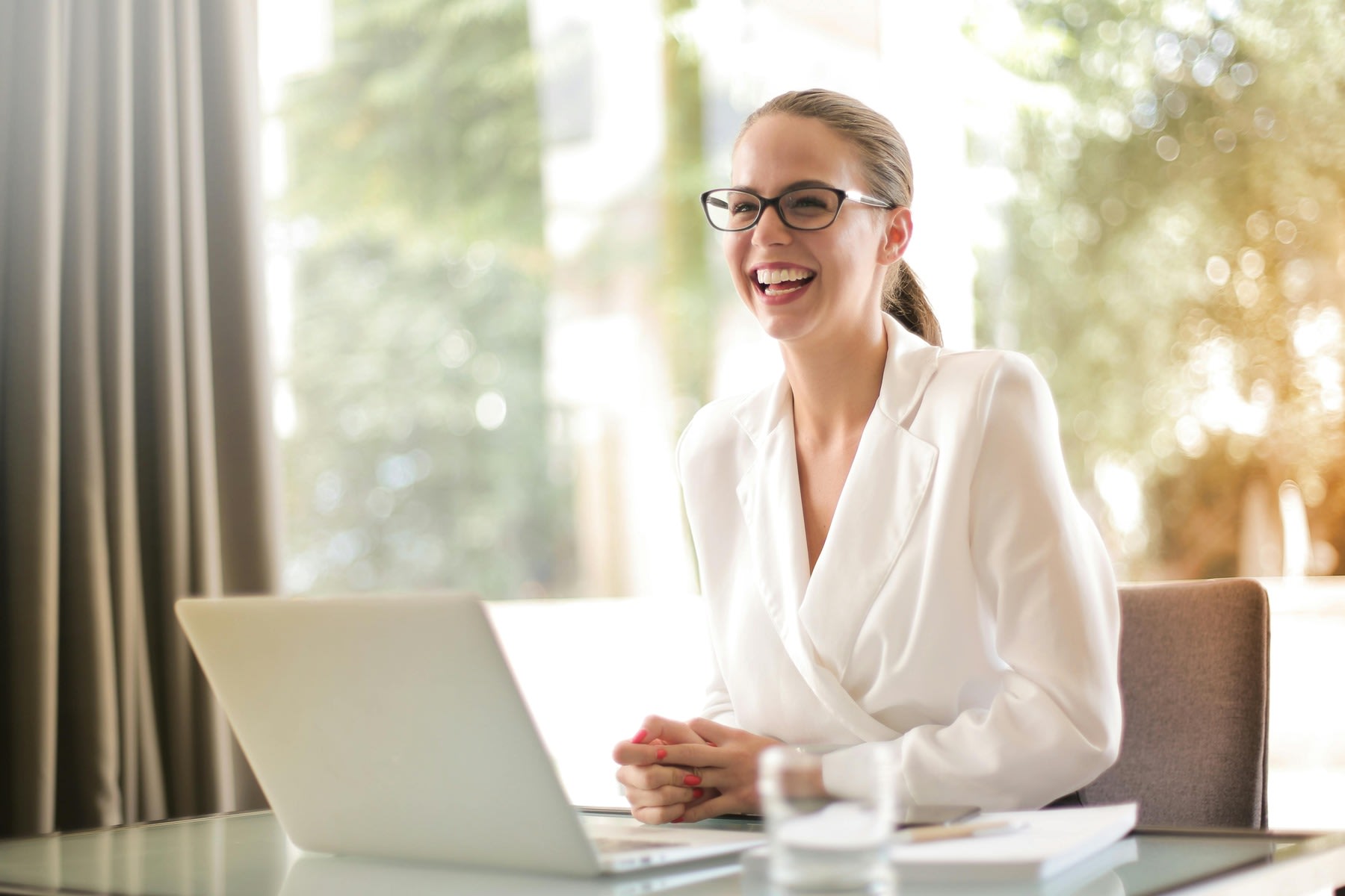 Woman smiling wide while seated at her office