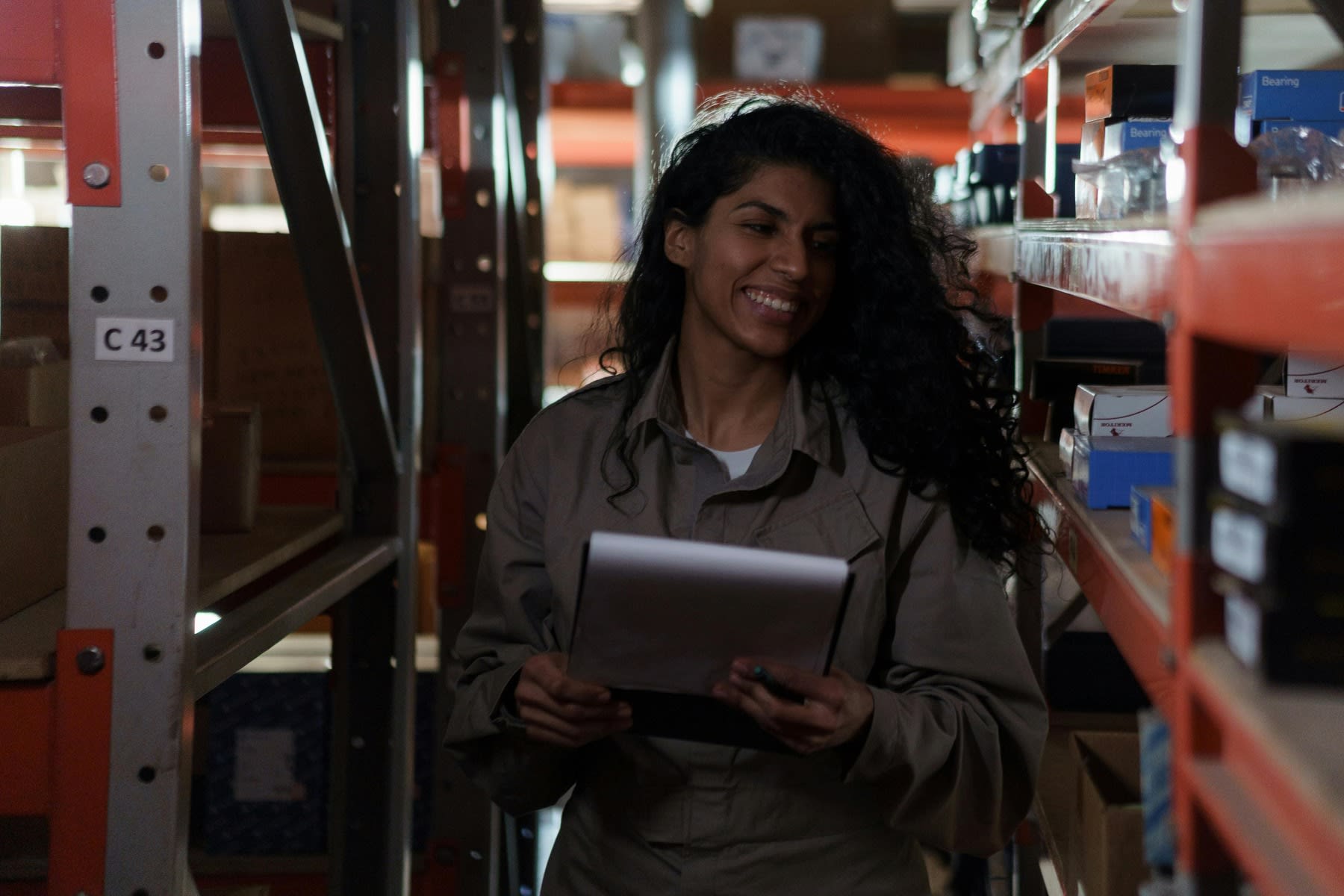 Woman holding a clipboard while checking supplies on a warehouse