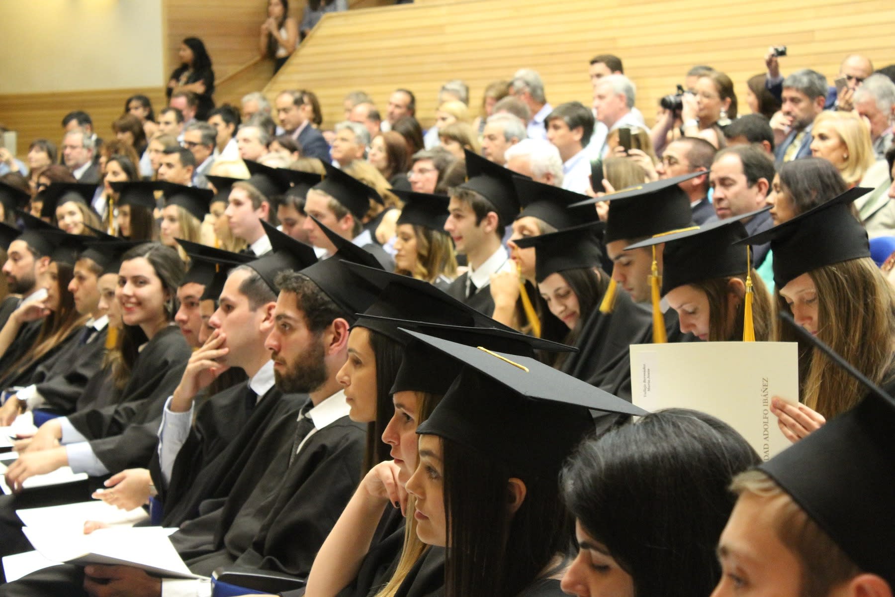 Students wearing graduation robes all seated for their closing ceremony