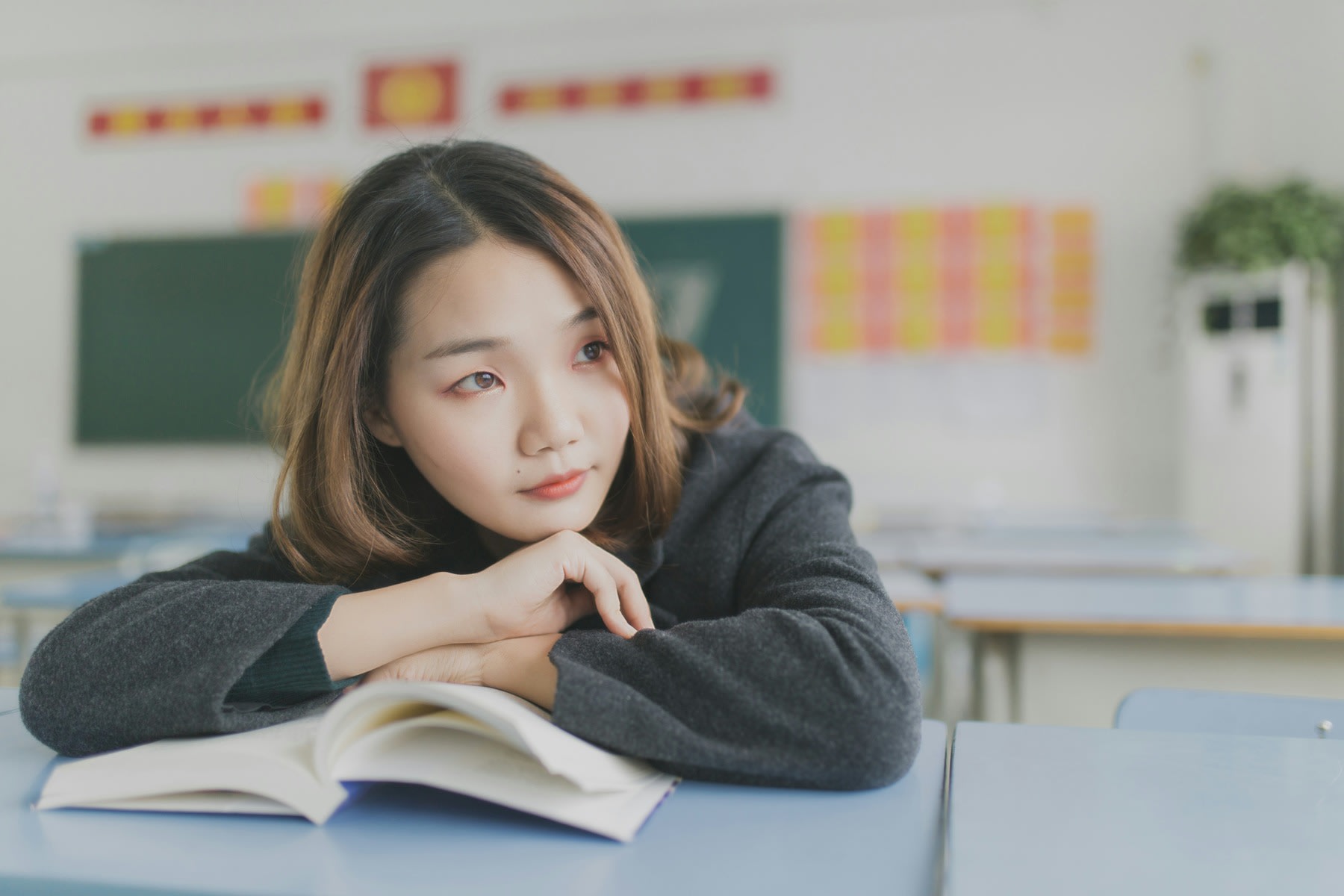 Woman leaning her body close to the table, in between reading