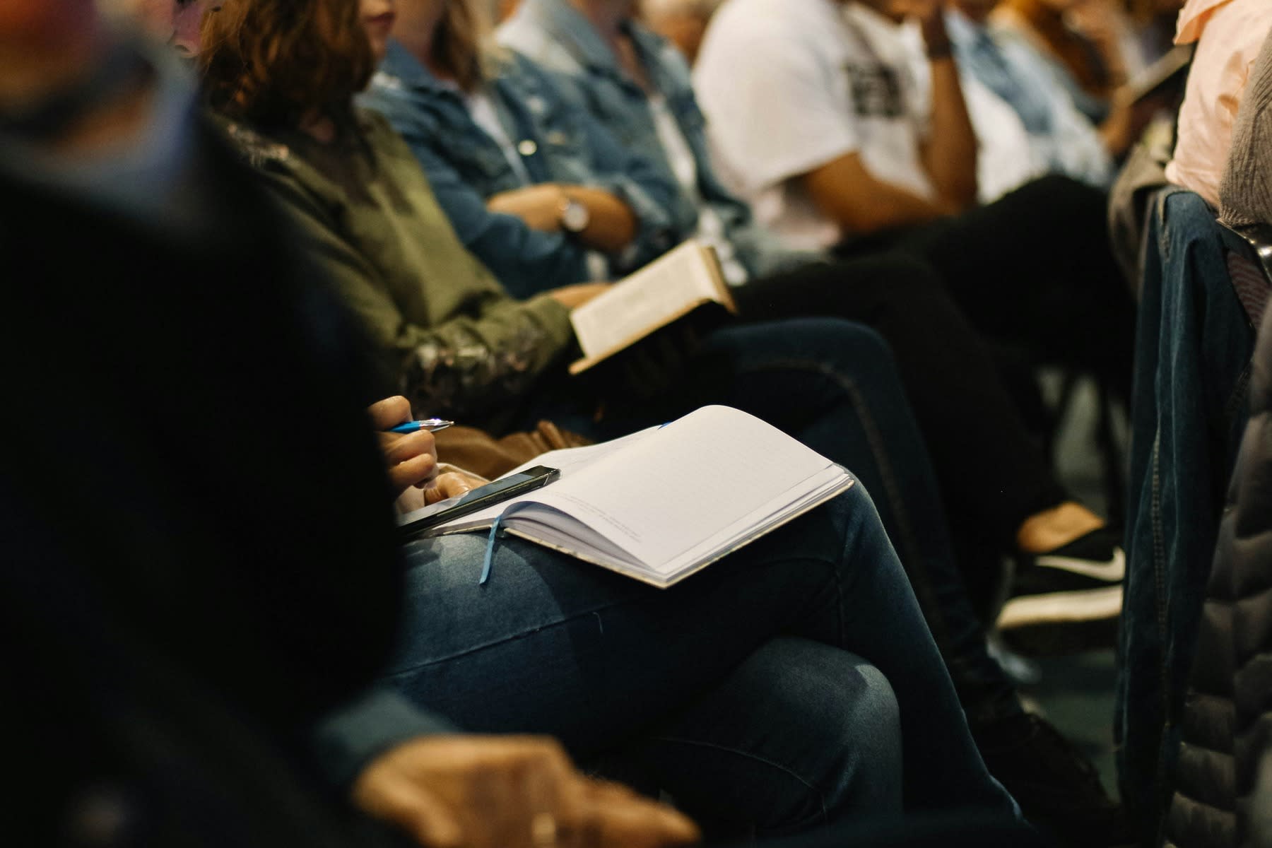 Students writing down notes during a sit down lecture