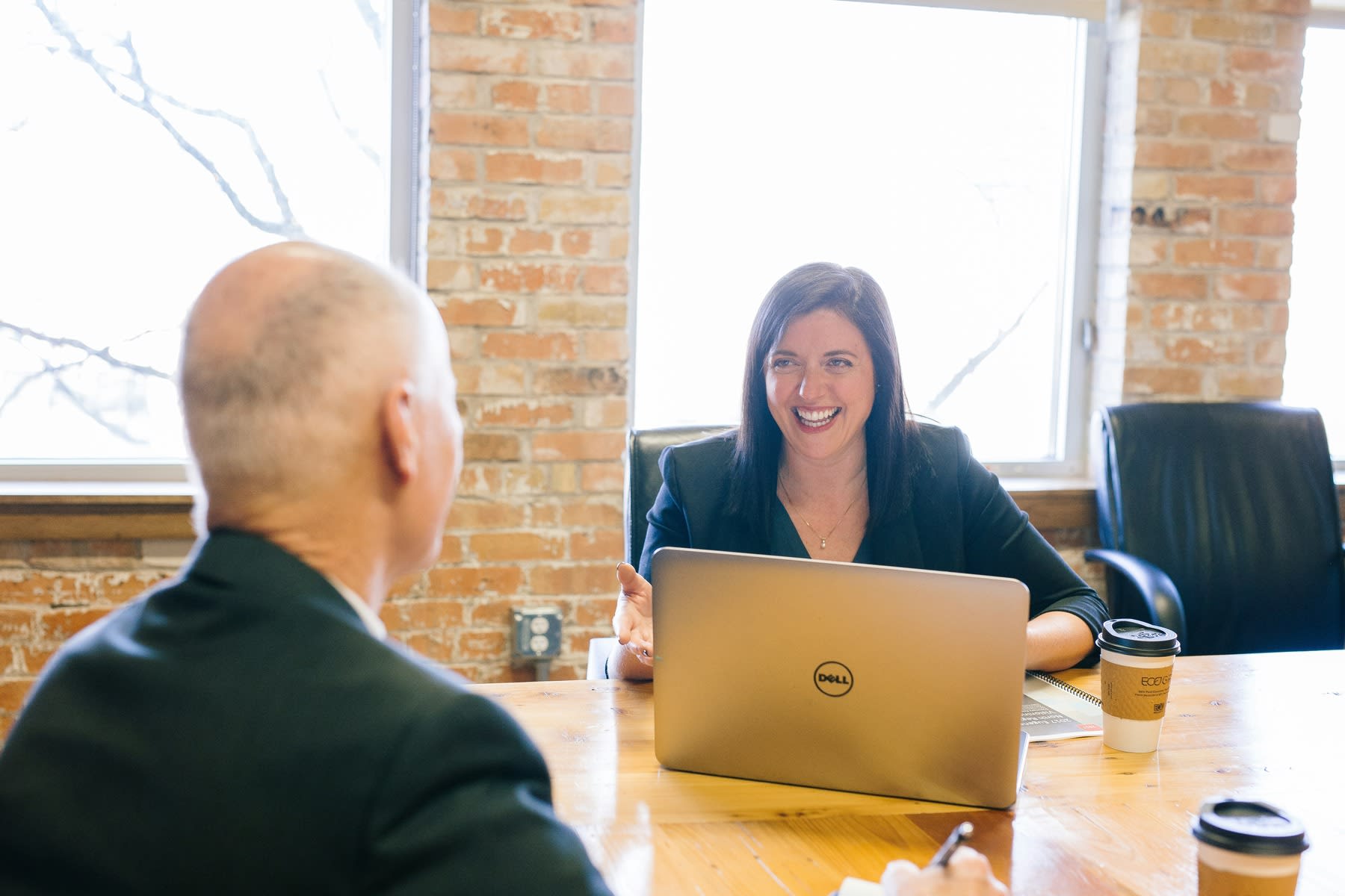 Woman smiling widely while she's in a meeting with her boss
