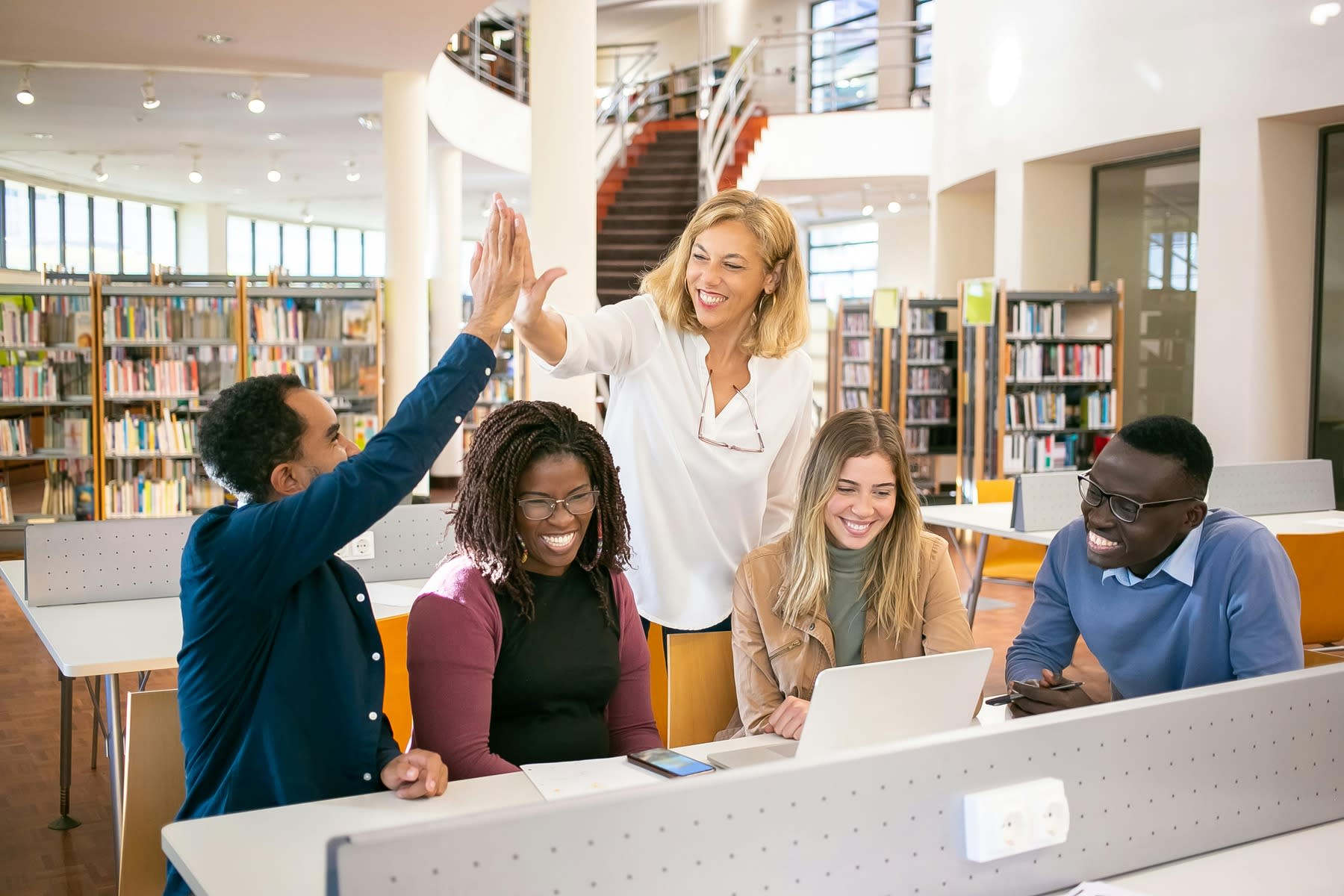 Woman exchanging a high five with a student