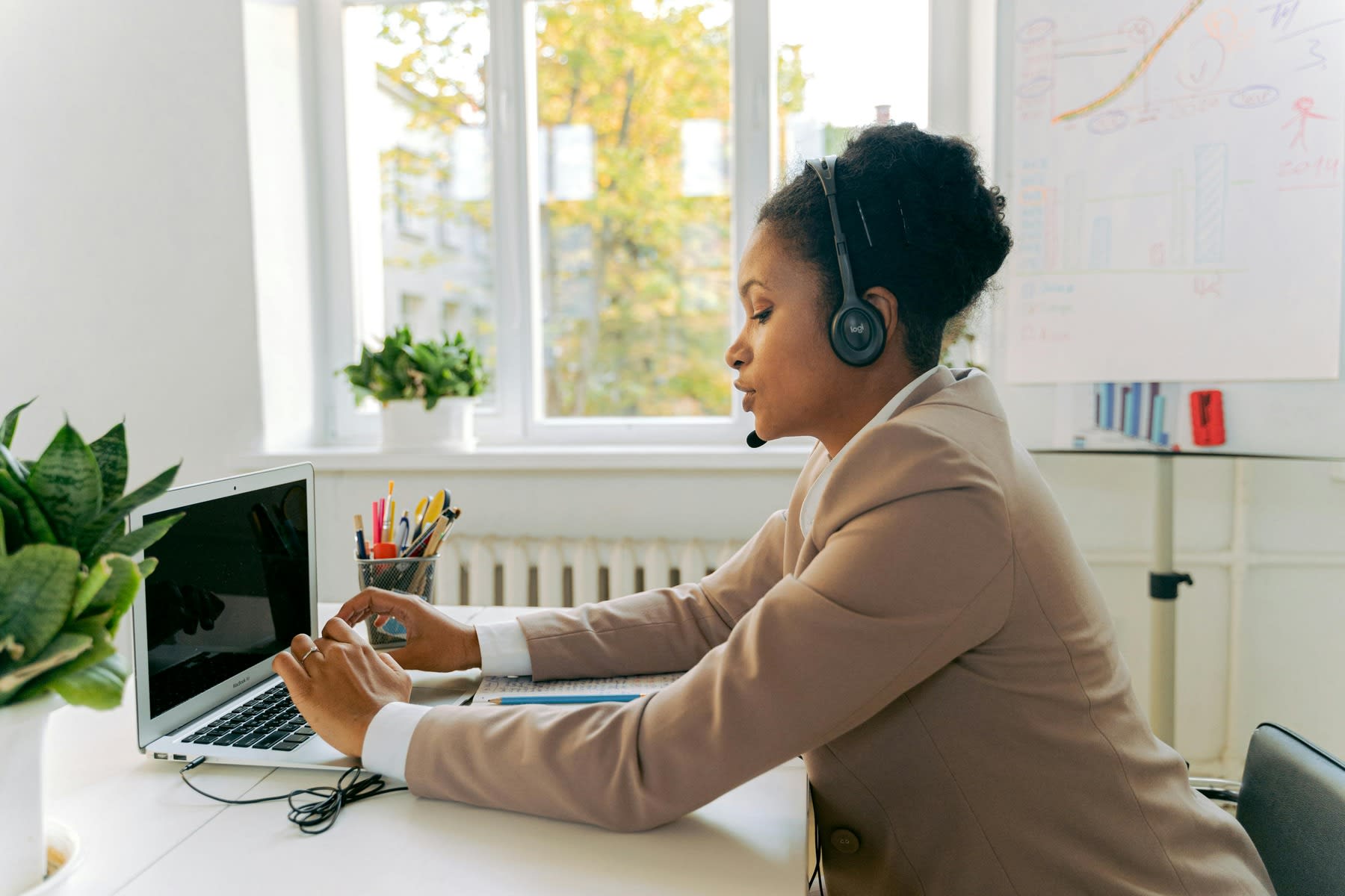 Woman wearing a headset while handling calls with her laptop