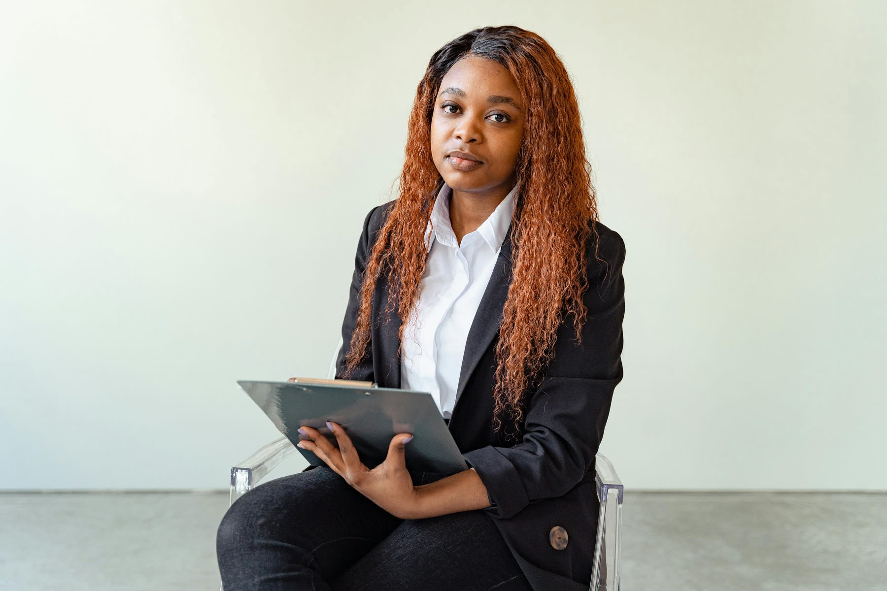 Woman wearing a suit while holding a clipboard