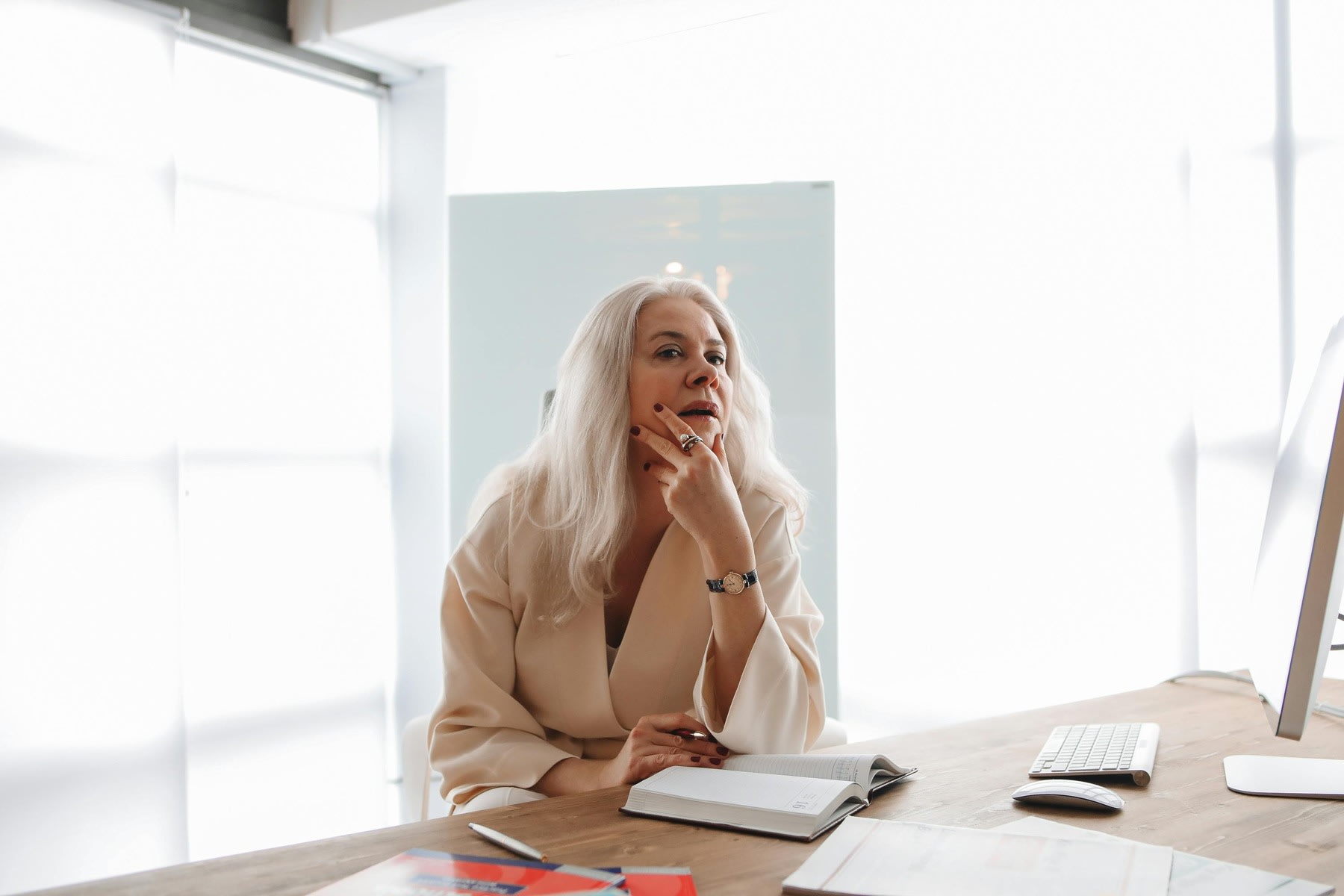 Woman looking at a distance while she has an opened book on her table