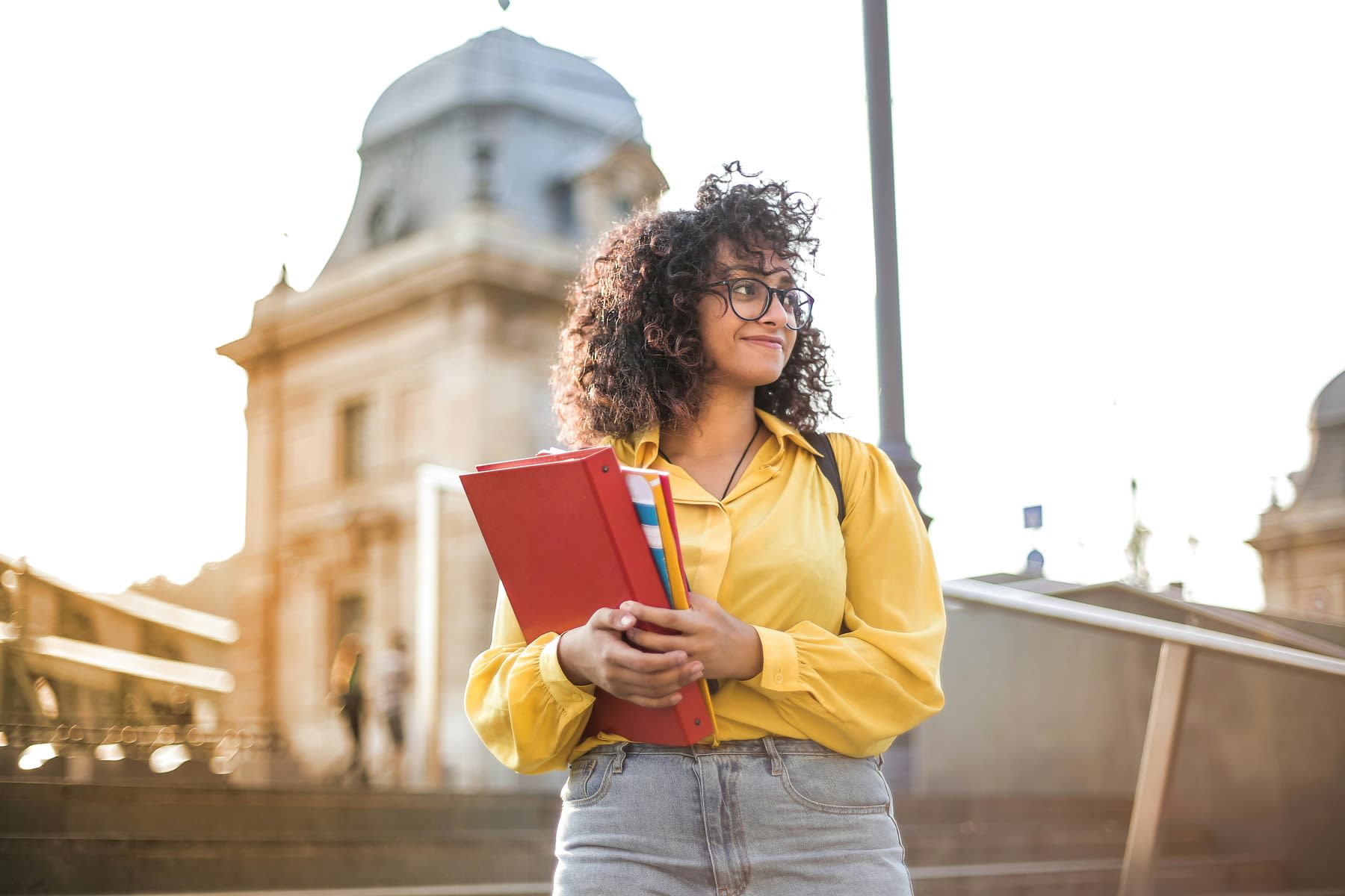 Woman holding books and binders on her way to class