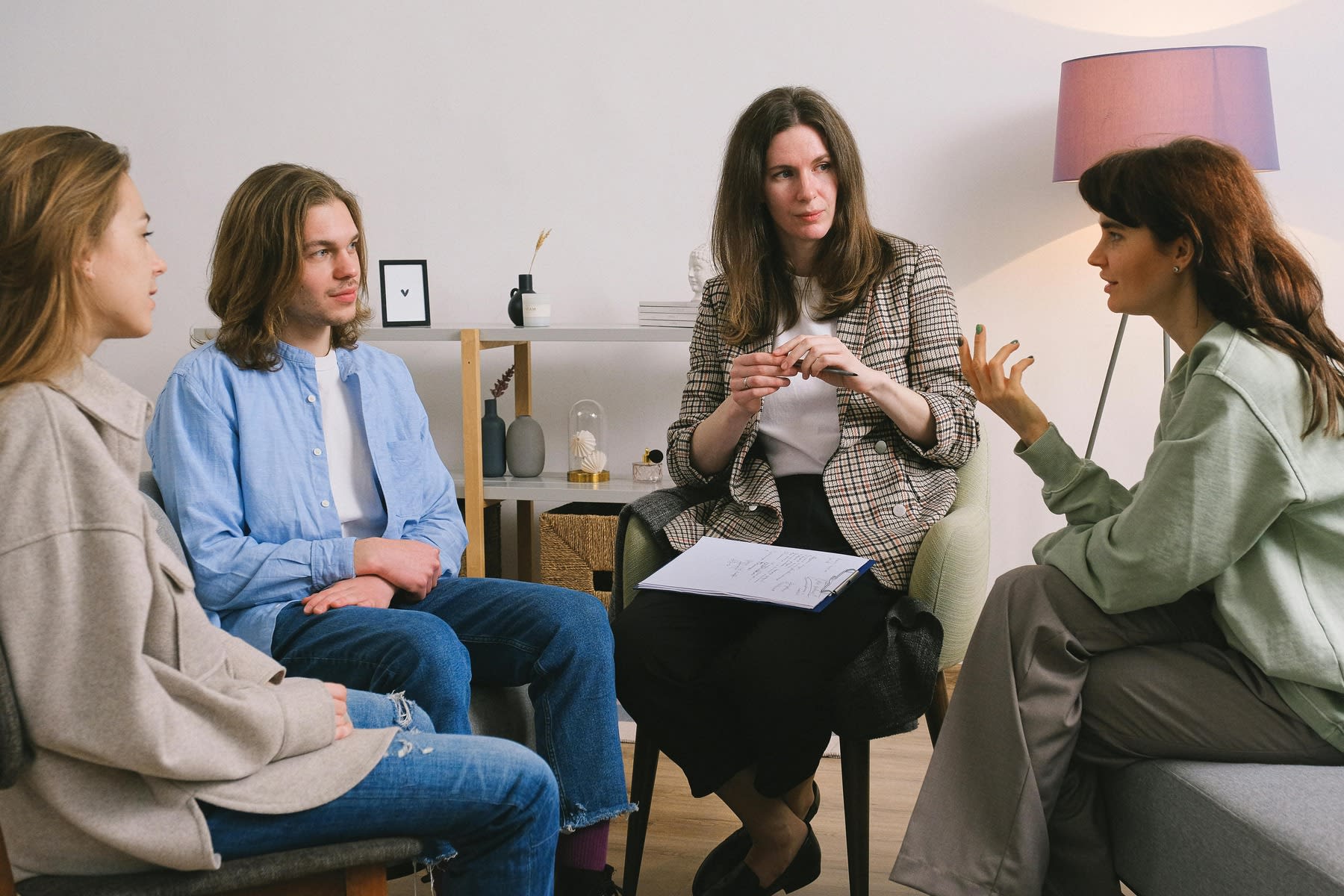 Woman holding a group therapy session with college students