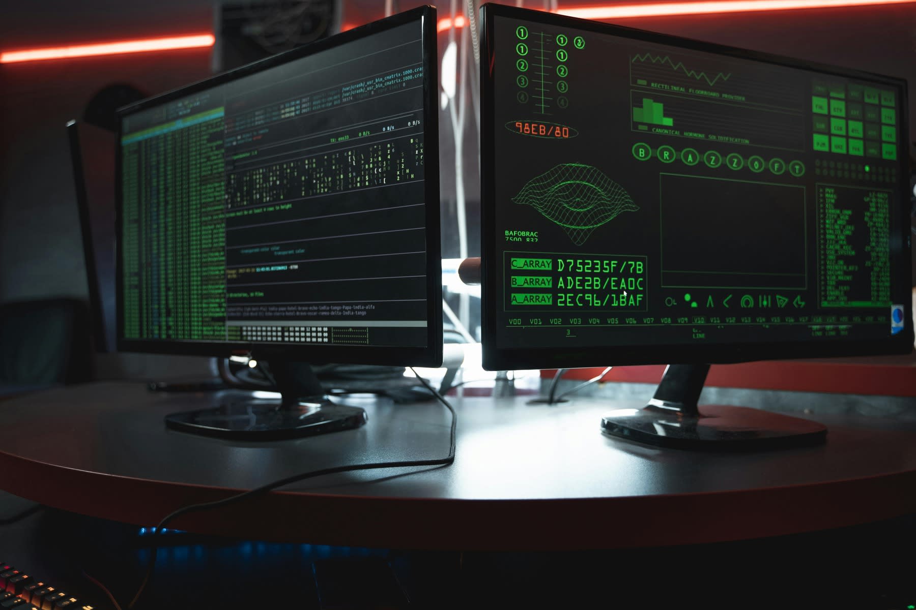 Two monitors showing a system being hacked